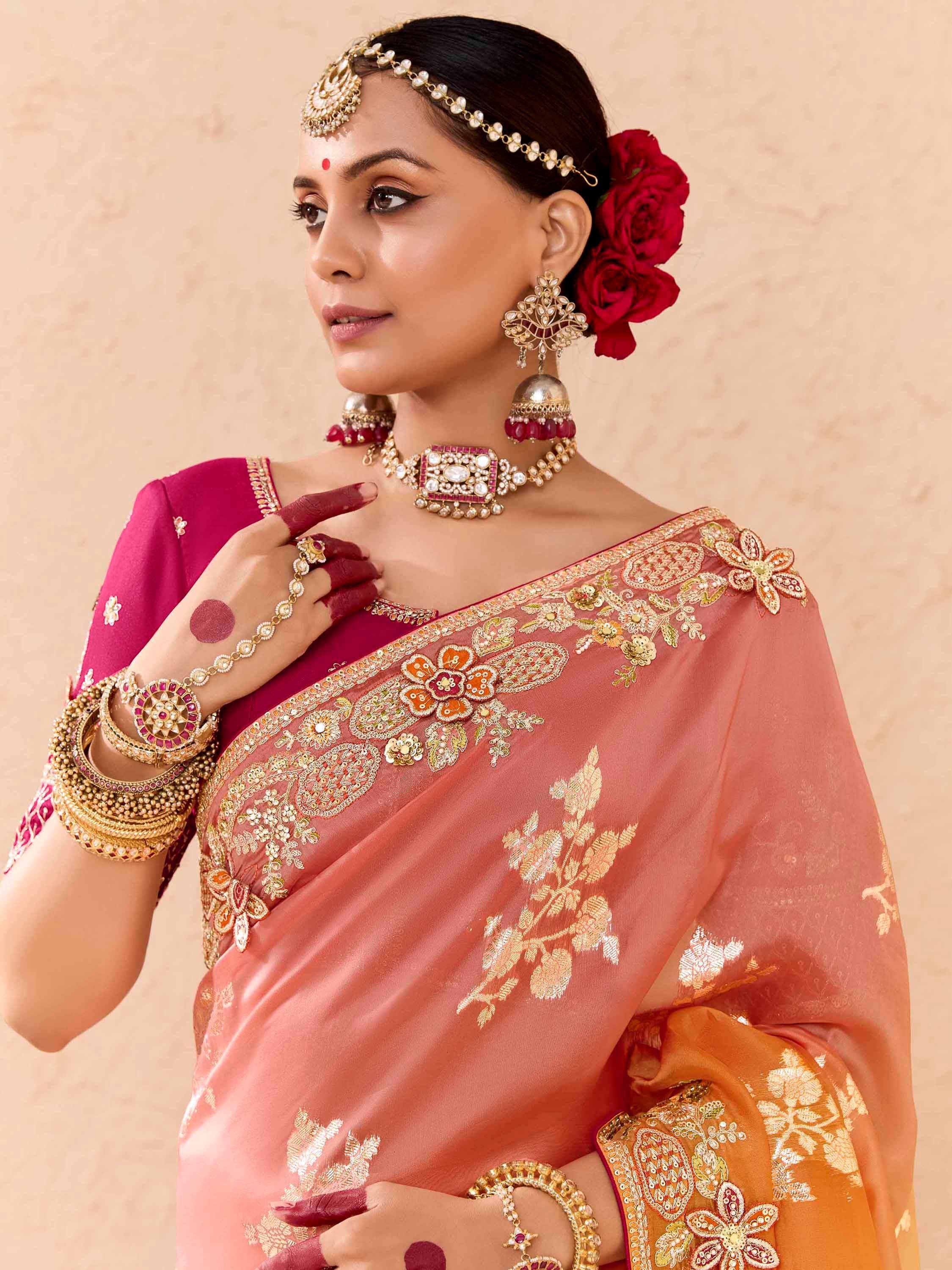 Woman in embroidered peach saree with gold floral work, pink blouse, and traditional Indian jewelry for festive occasions