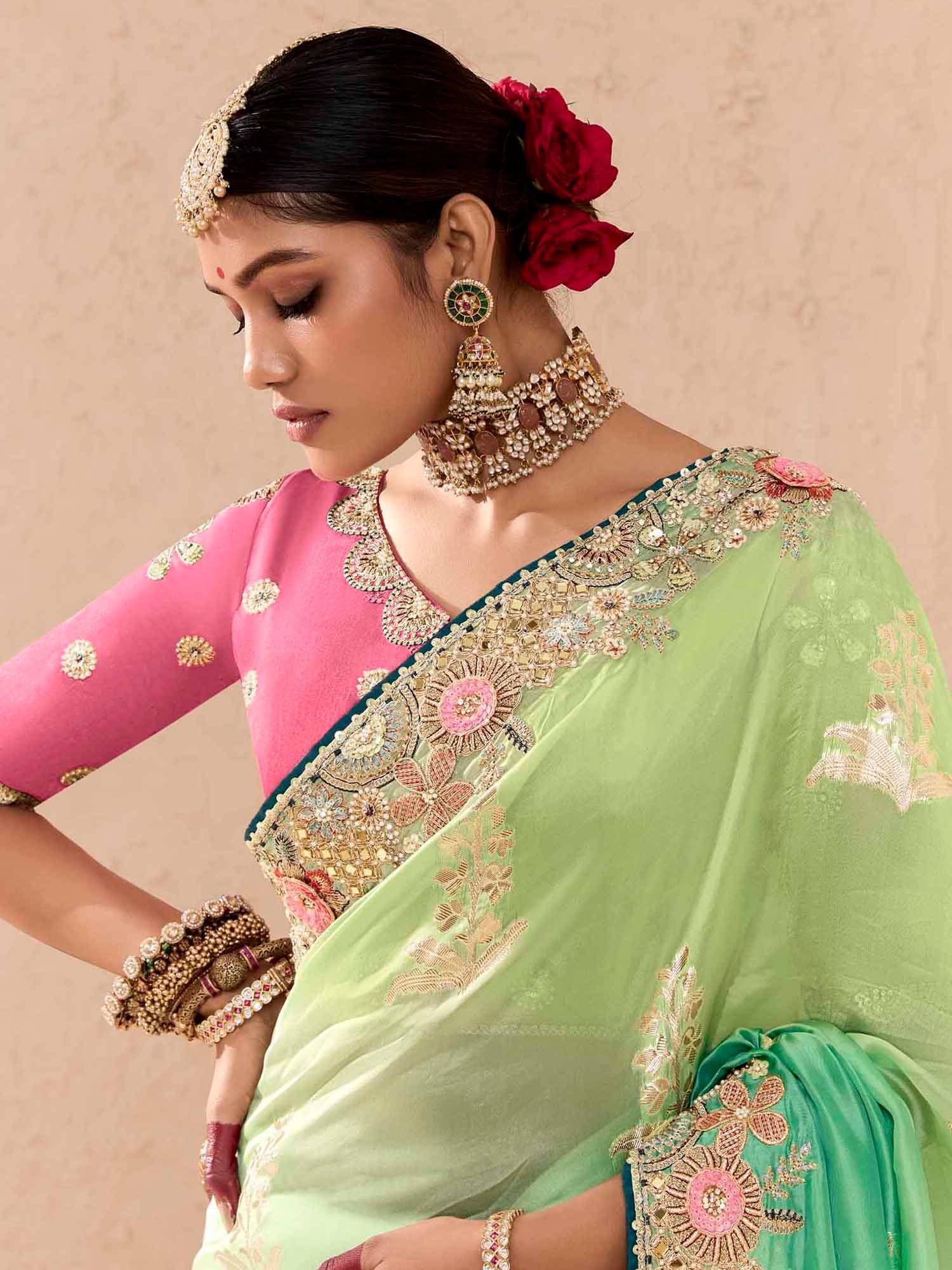 Elegant green saree with pink blouse, floral embroidery, and traditional Indian jewelry for festive occasions