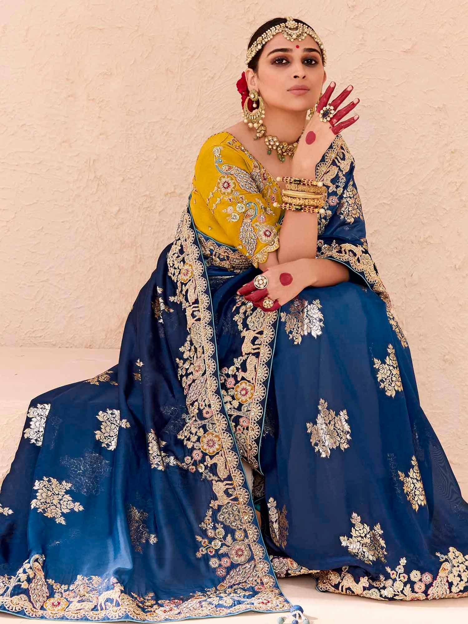 Blue and yellow embroidered lehenga choli with gold detailing, perfect for Indian weddings and festive occasions.