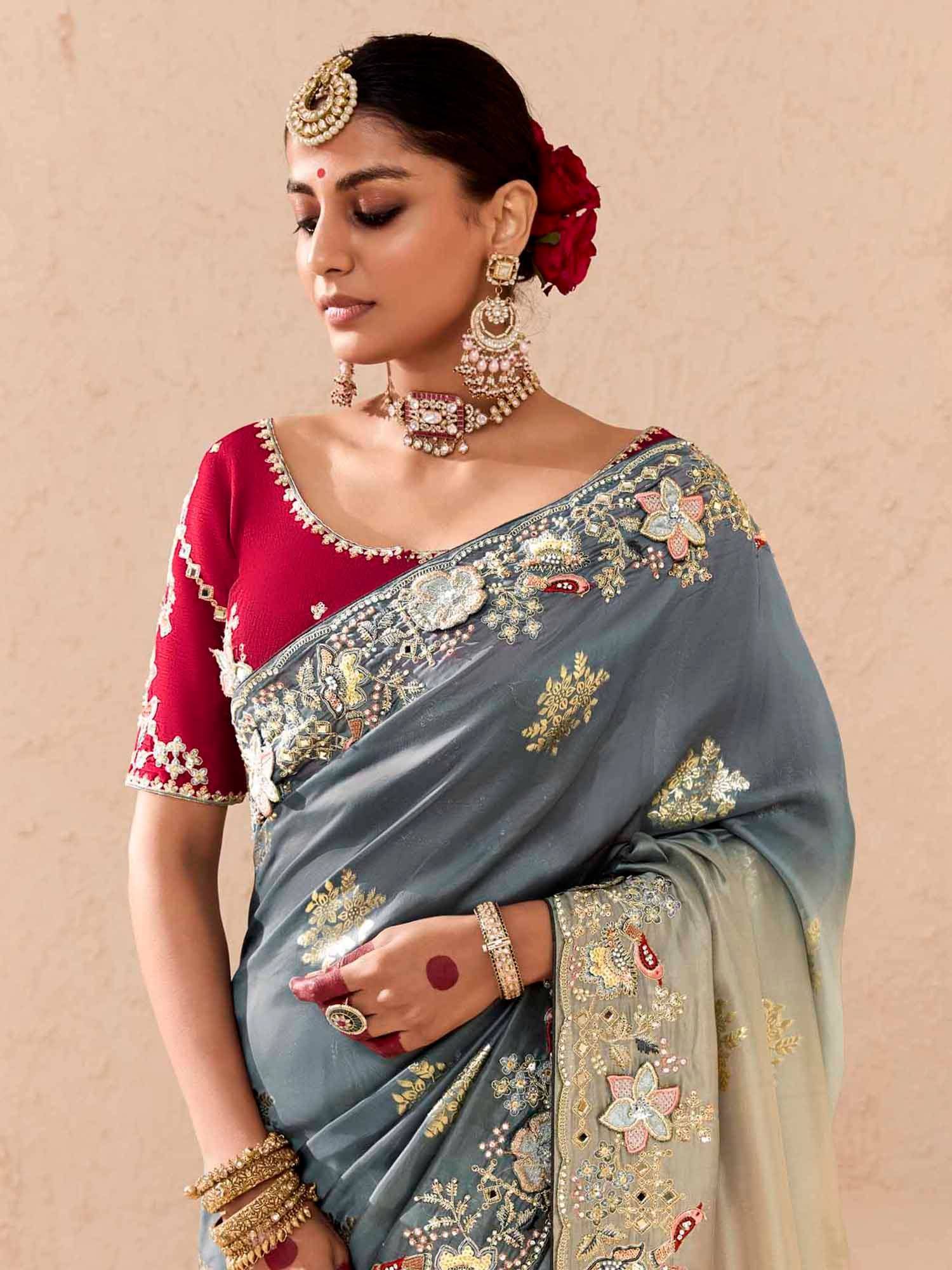 Elegant grey saree with gold floral embroidery, paired with a red blouse and traditional Indian jewelry for festive occasions.