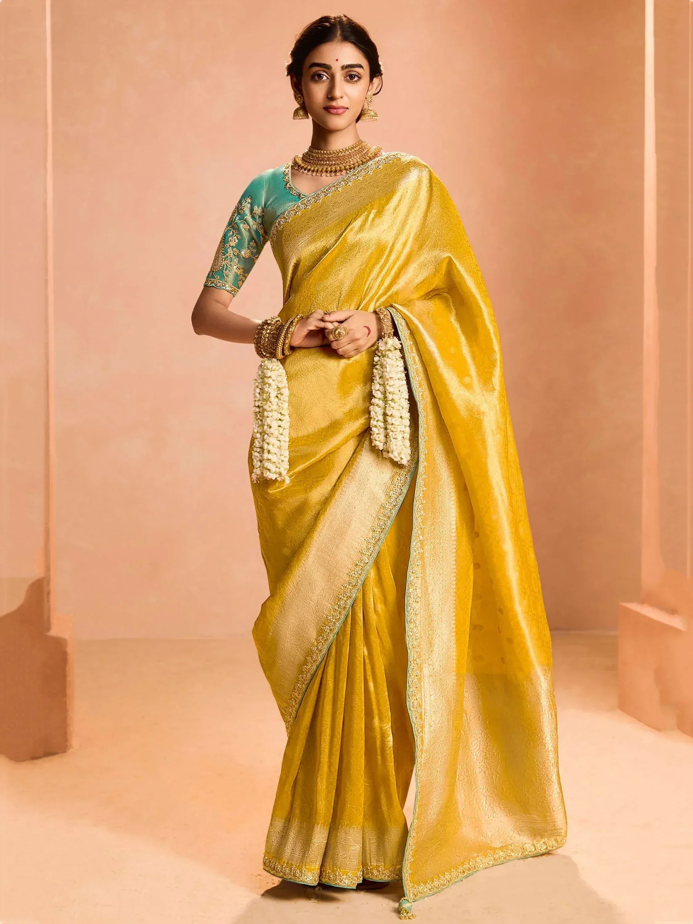 Yellow silk saree with gold border and teal blouse, traditional Indian ethnic wear for women