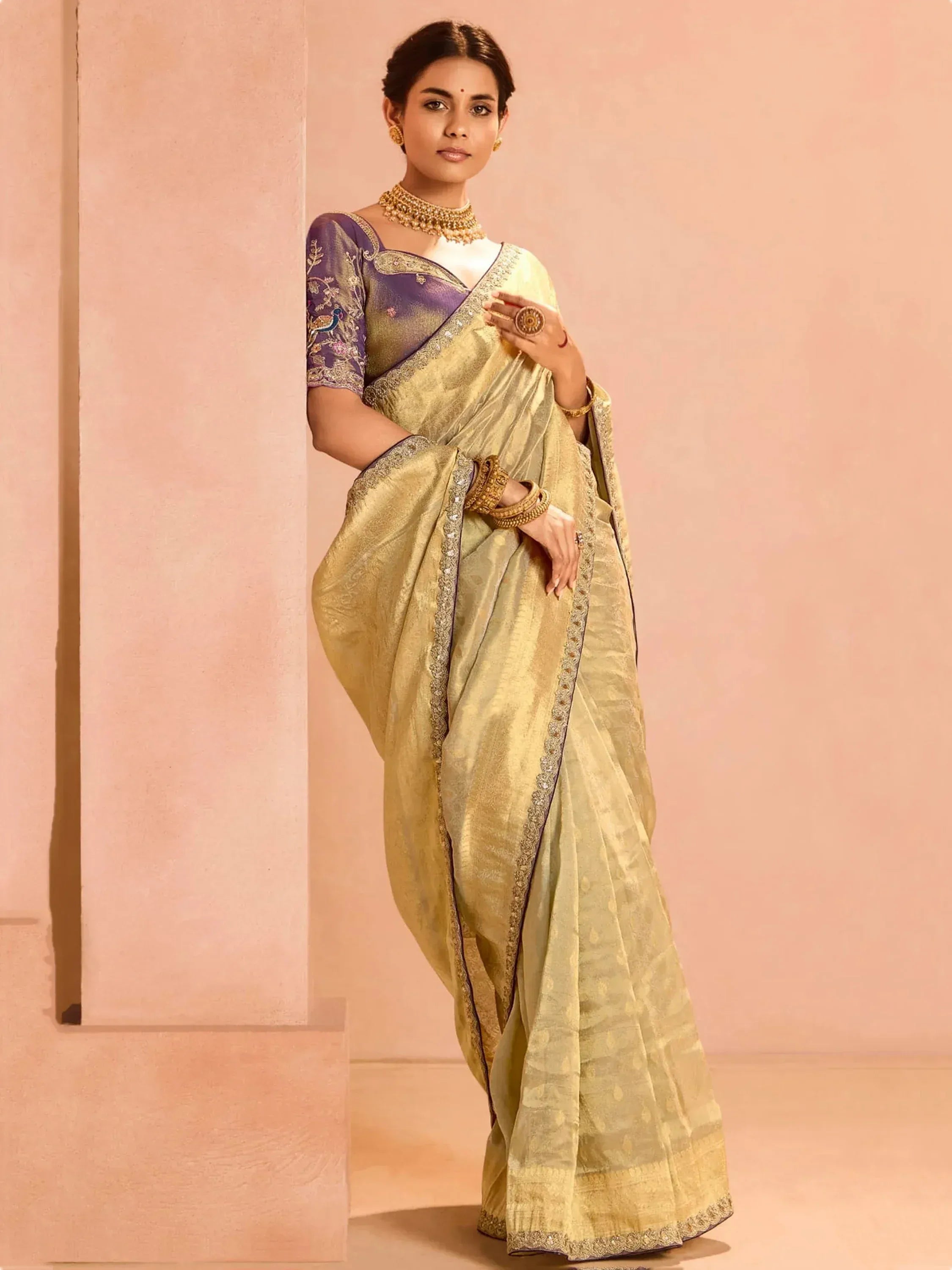 Elegant golden saree with purple embroidered blouse, perfect for Indian ethnic wear occasions.