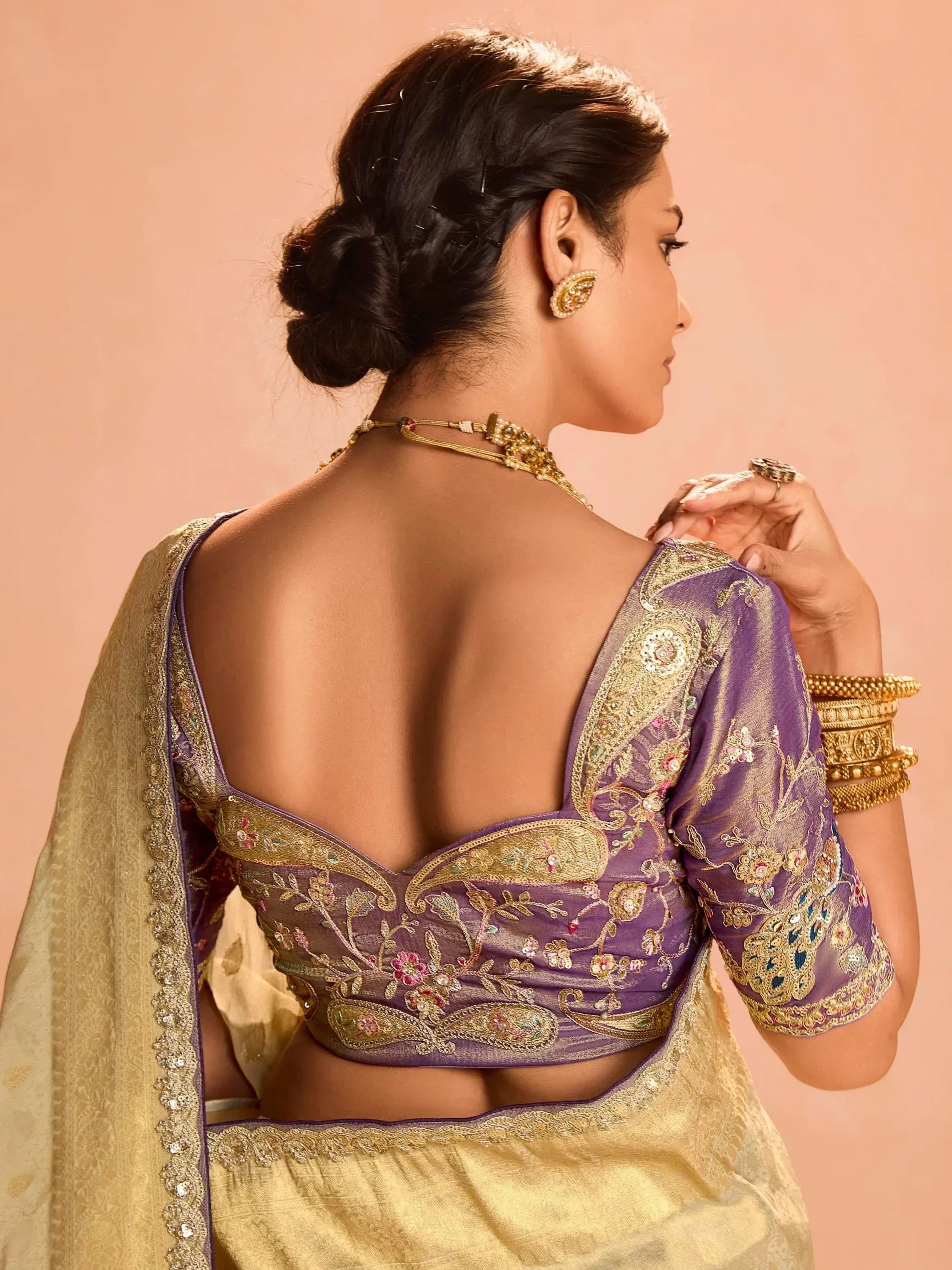 Purple embroidered blouse with gold detailing, paired with golden saree, showcasing ethnic Indian wear.
