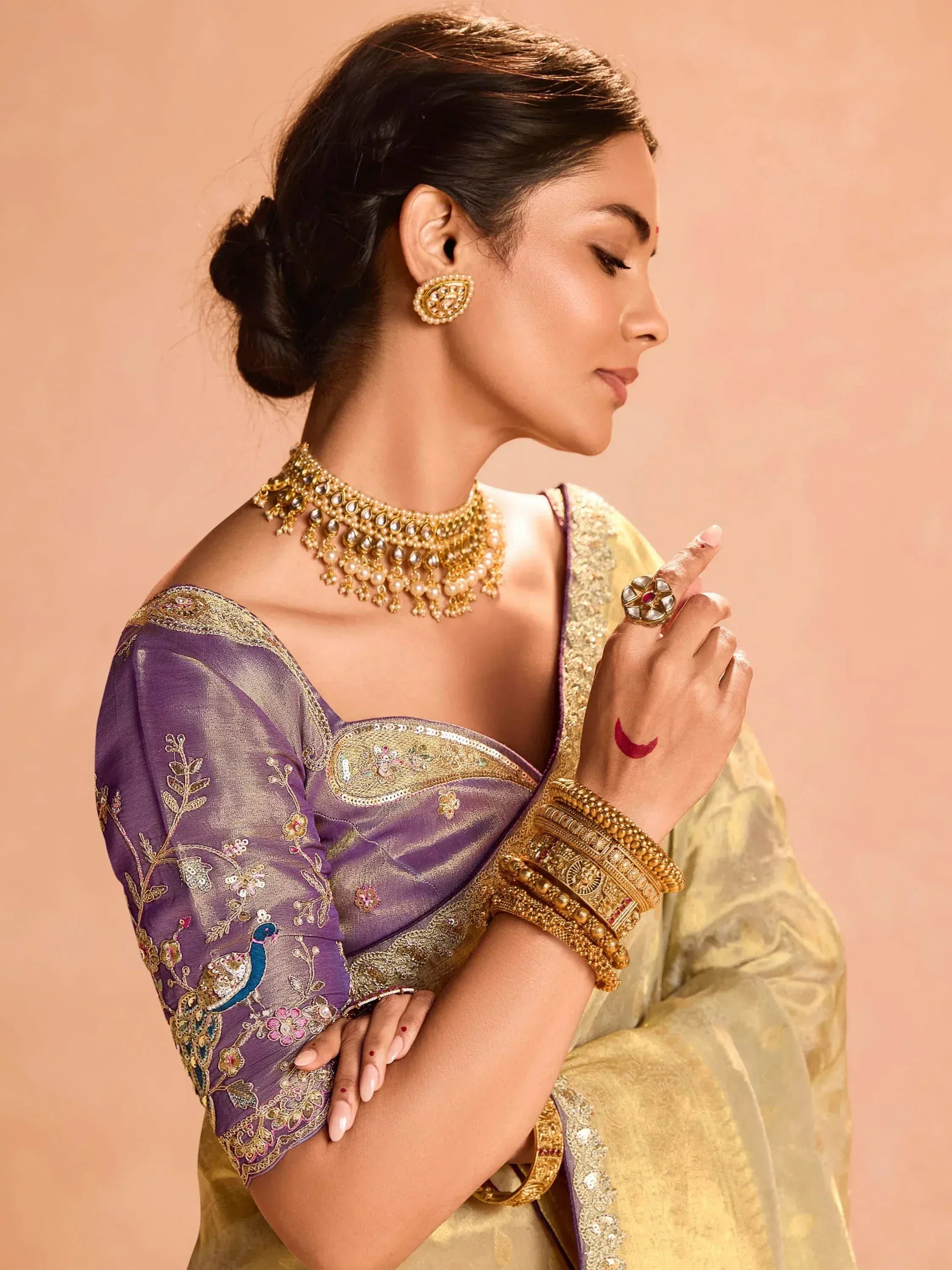 Elegant woman in purple and gold embroidered saree with traditional jewelry