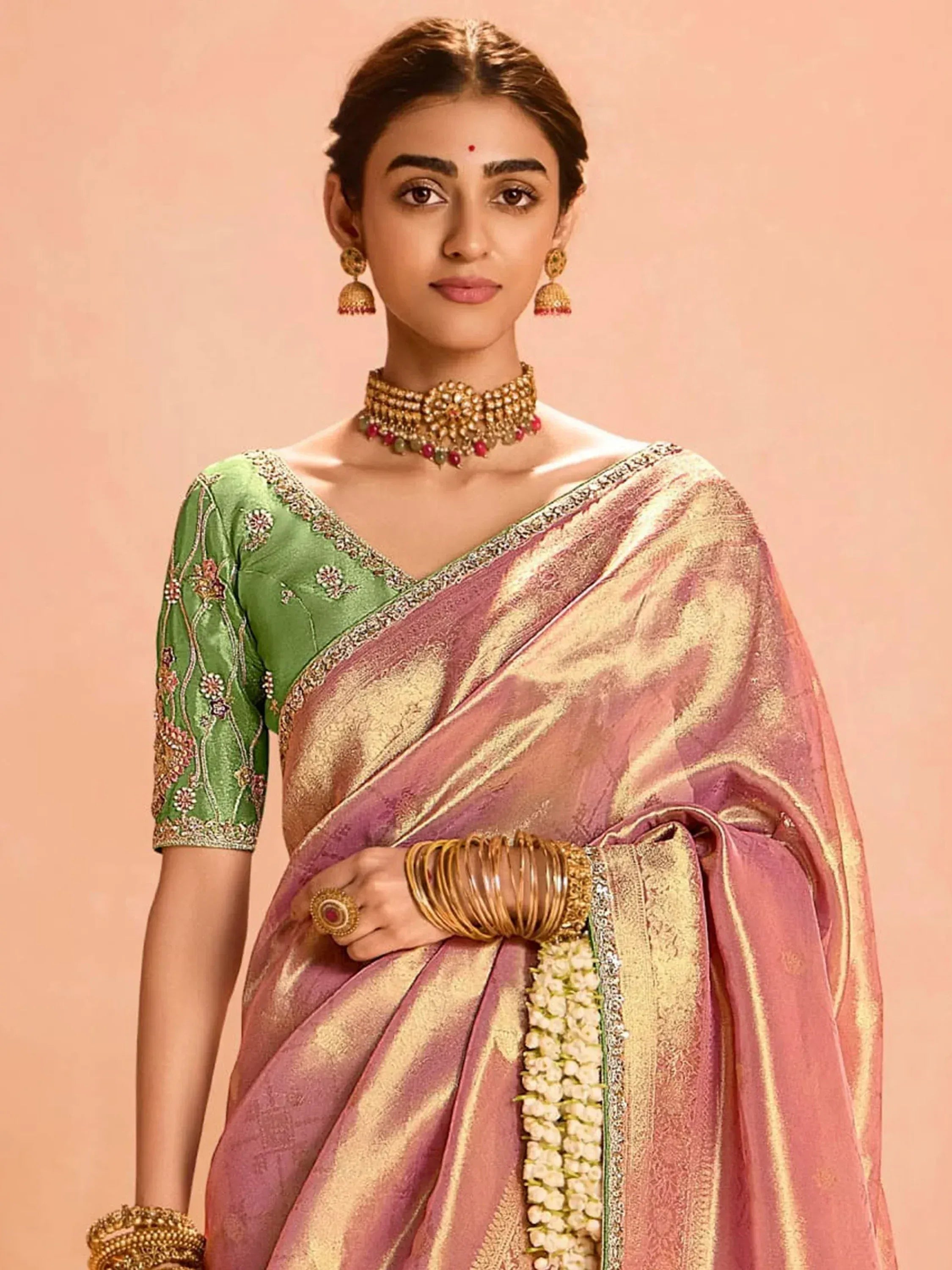 Woman in pink and gold saree with green embroidered blouse, traditional Indian ethnic wear