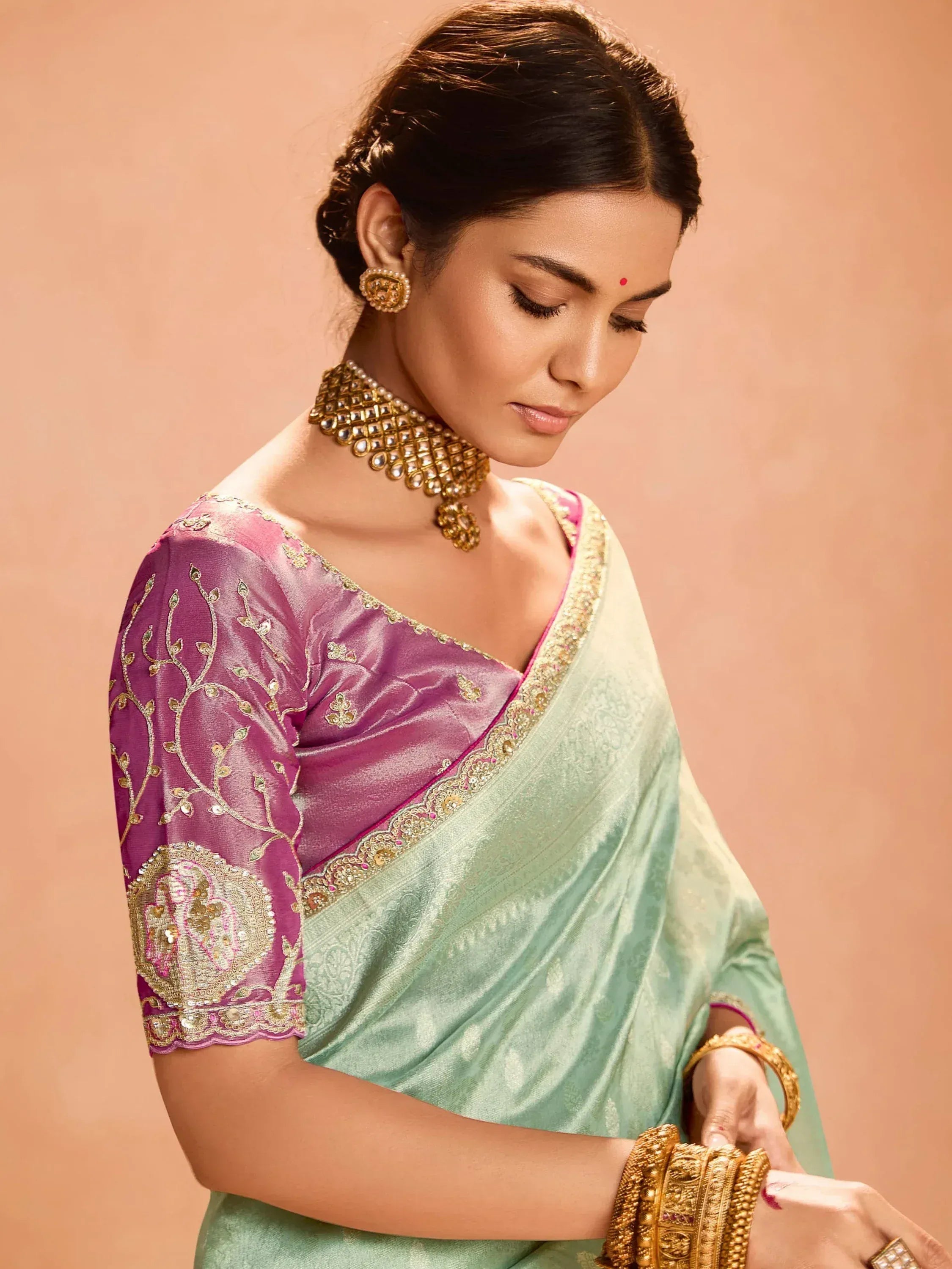 Elegant mint green saree with purple blouse, gold embroidery, and traditional jewelry