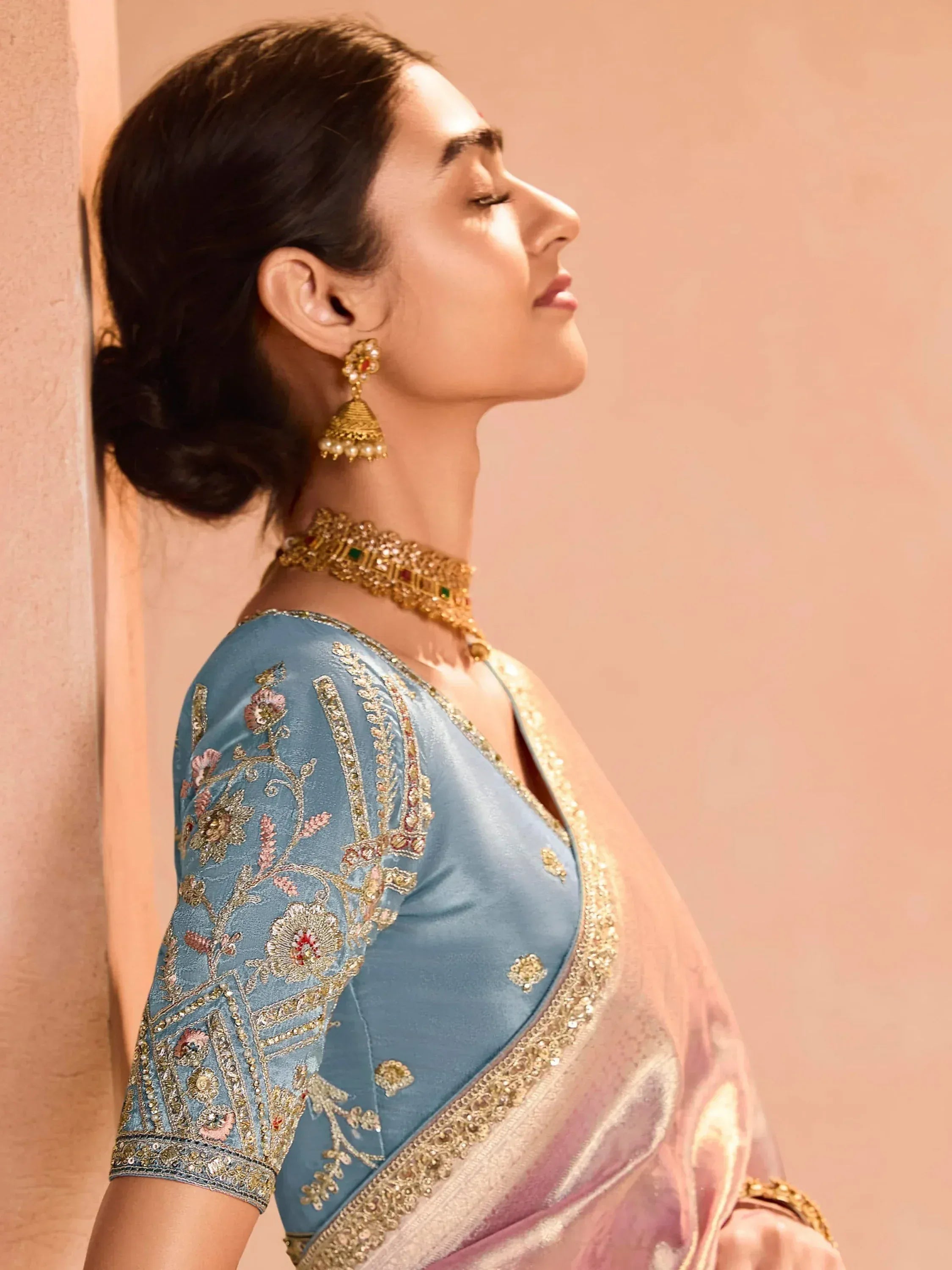 Elegant blue embroidered saree with gold detailing and traditional jewelry