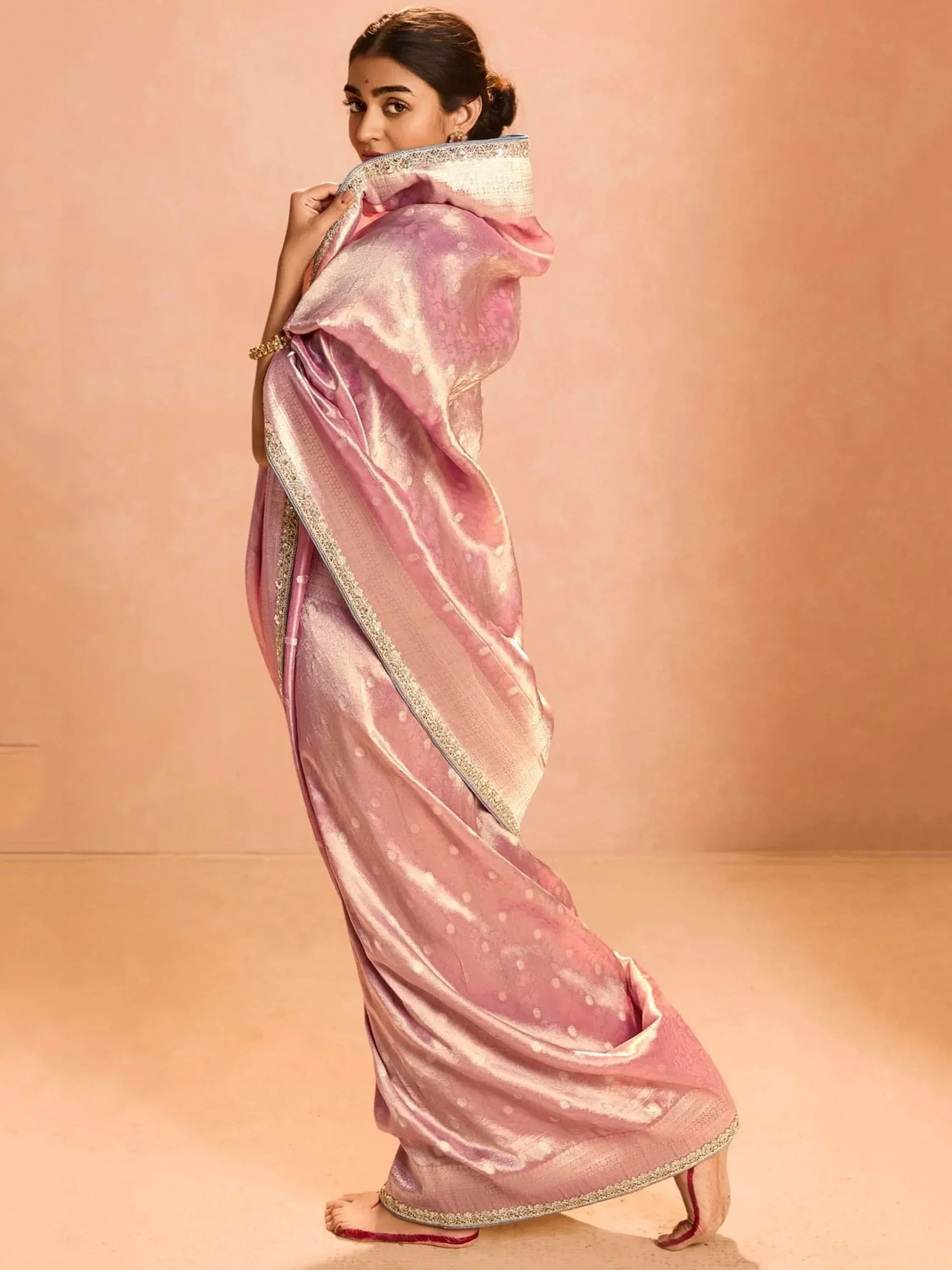 Elegant pink designer saree with intricate gold border and subtle polka dots, perfect for ethnic occasions.