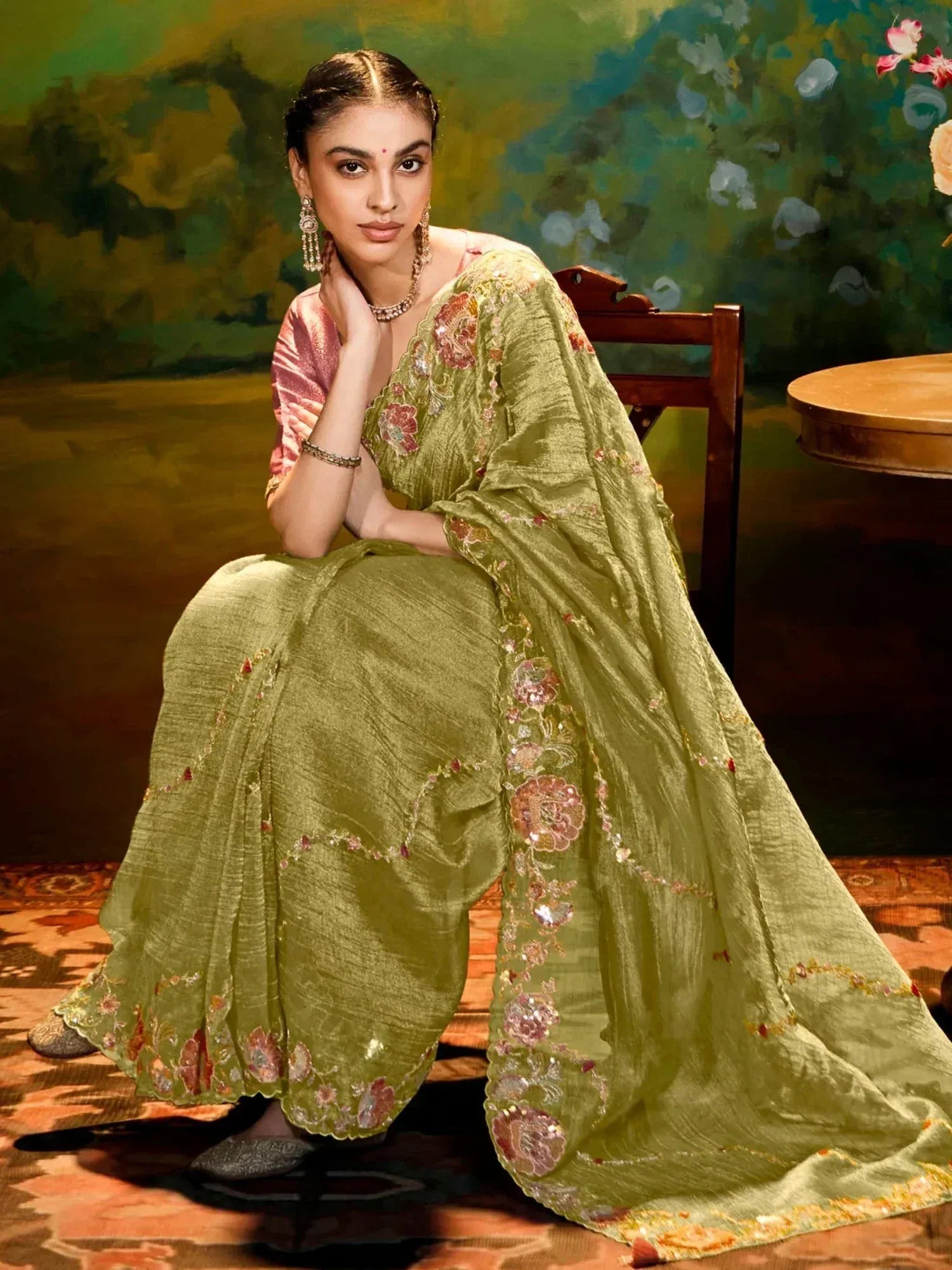 Woman in olive green embroidered saree with floral motifs, traditional Indian ethnic wear