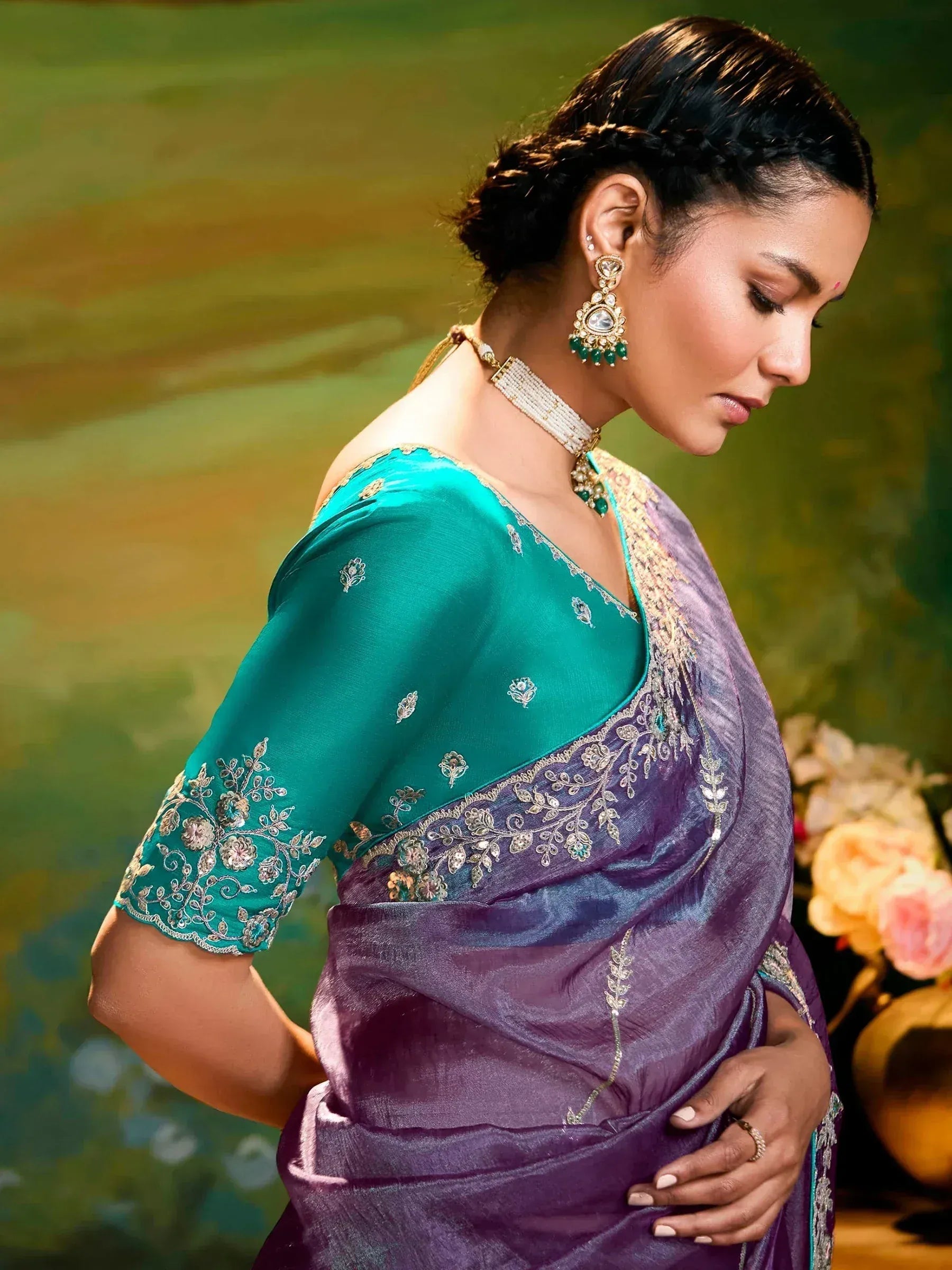 Purple and teal embroidered saree with gold detailing, paired with traditional jewelry for ethnic wear