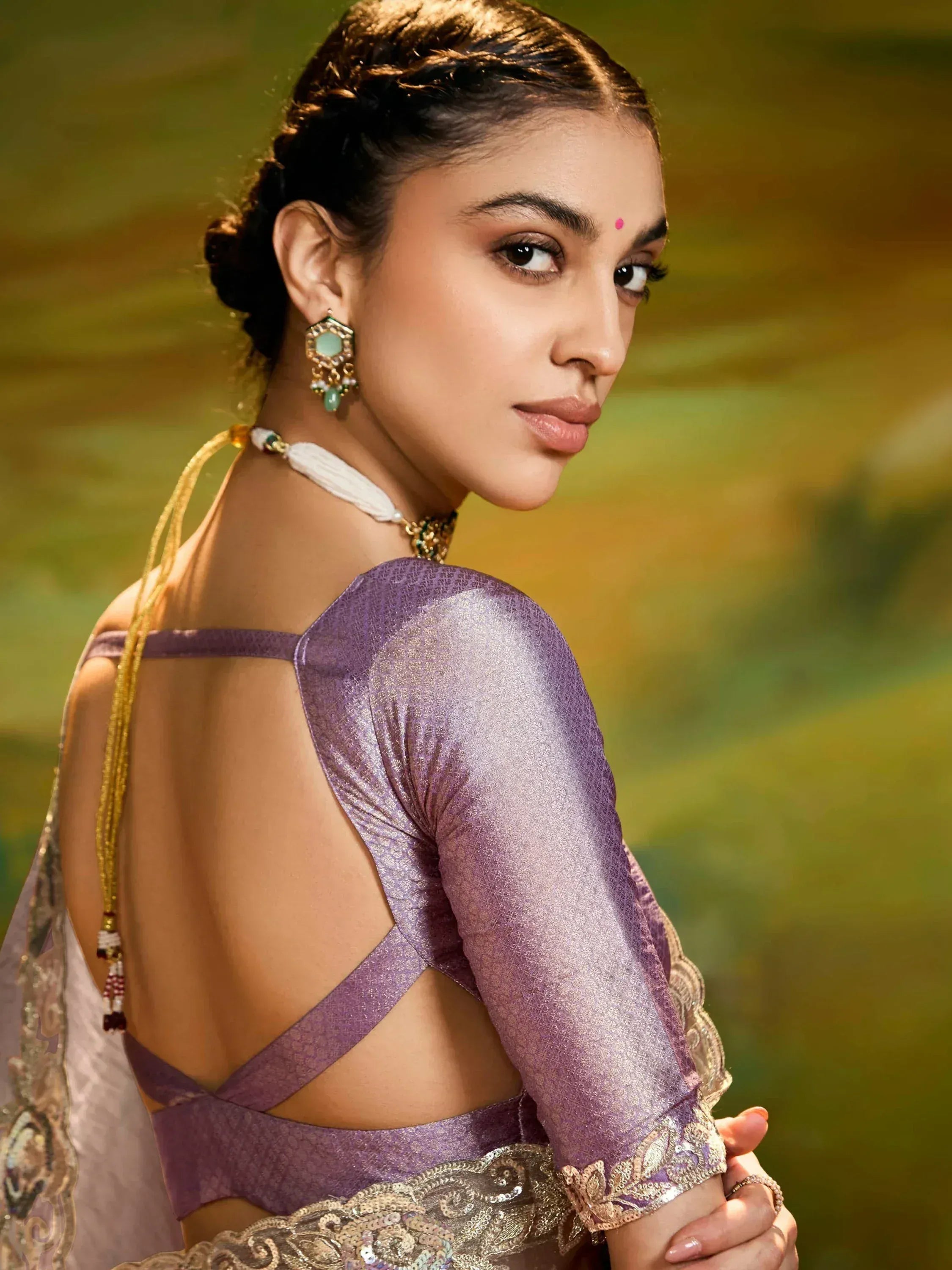 Purple designer lehenga choli with backless blouse, gold embroidery, and statement earrings for Indian ethnic wear