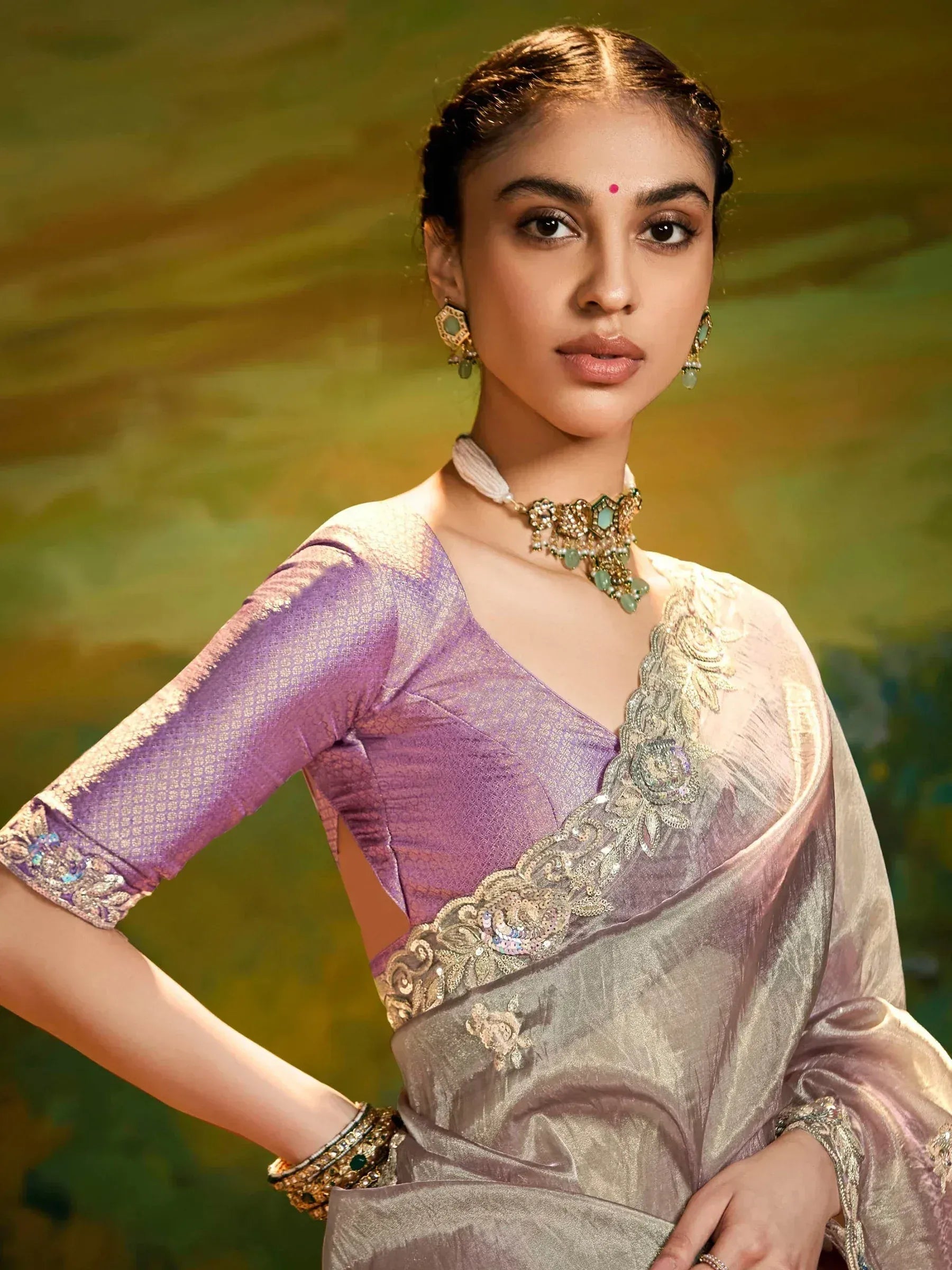 Woman in elegant purple and silver saree with gold embroidery, perfect for Indian ethnic occasions.