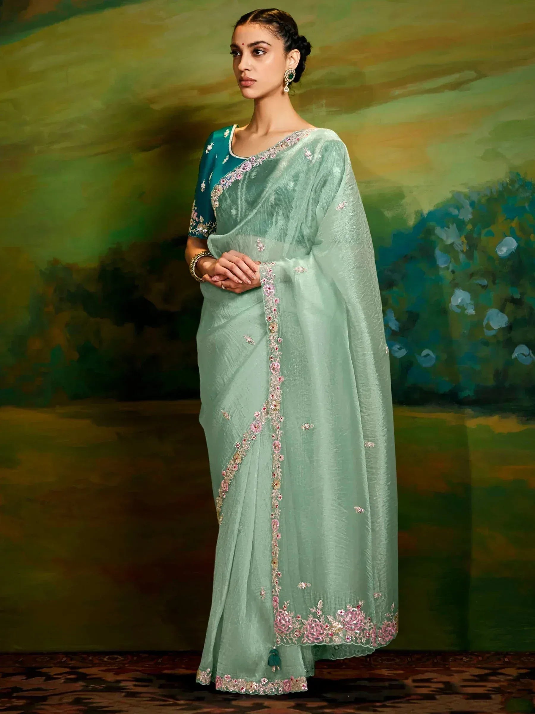 Mint green embroidered saree with floral detailing and teal blouse, perfect for Indian ethnic occasions.