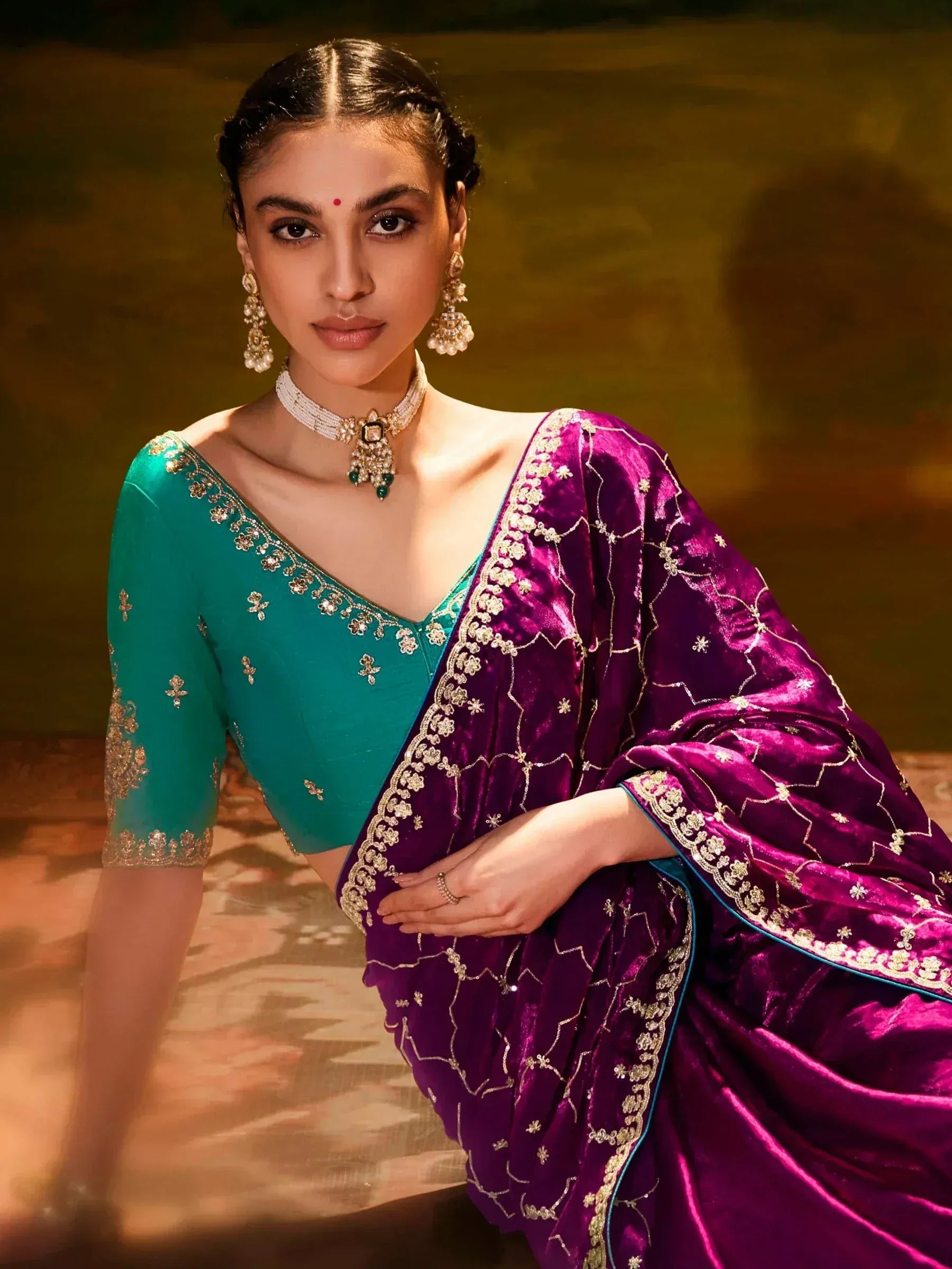 Woman in purple velvet saree with gold embroidery and green blouse, traditional Indian ethnic wear
