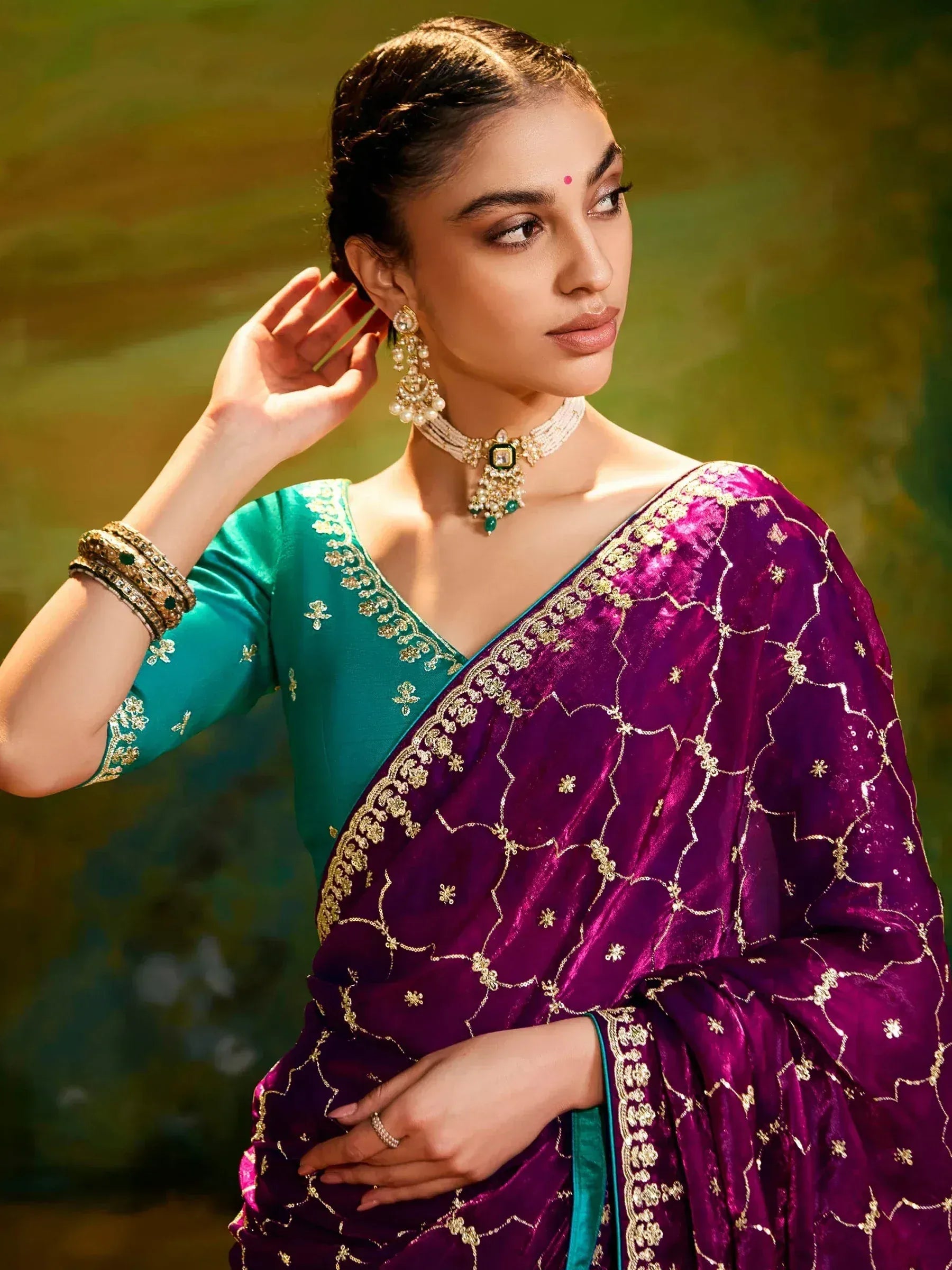 Purple velvet saree with gold embroidery, paired with green blouse and traditional jewelry for Indian ethnic wear