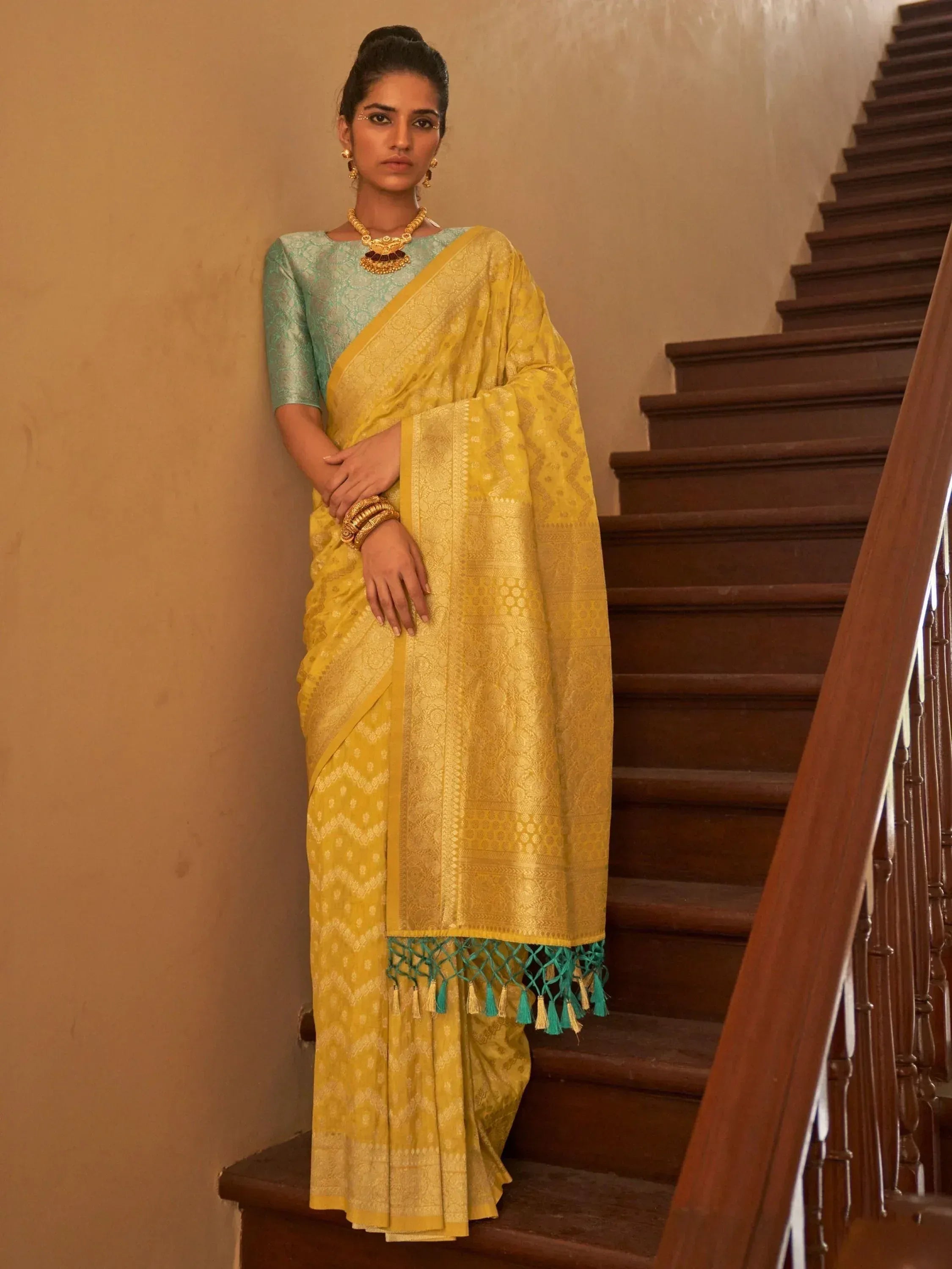 Yellow designer saree with teal blouse and tassels, perfect for Indian ethnic wear occasions