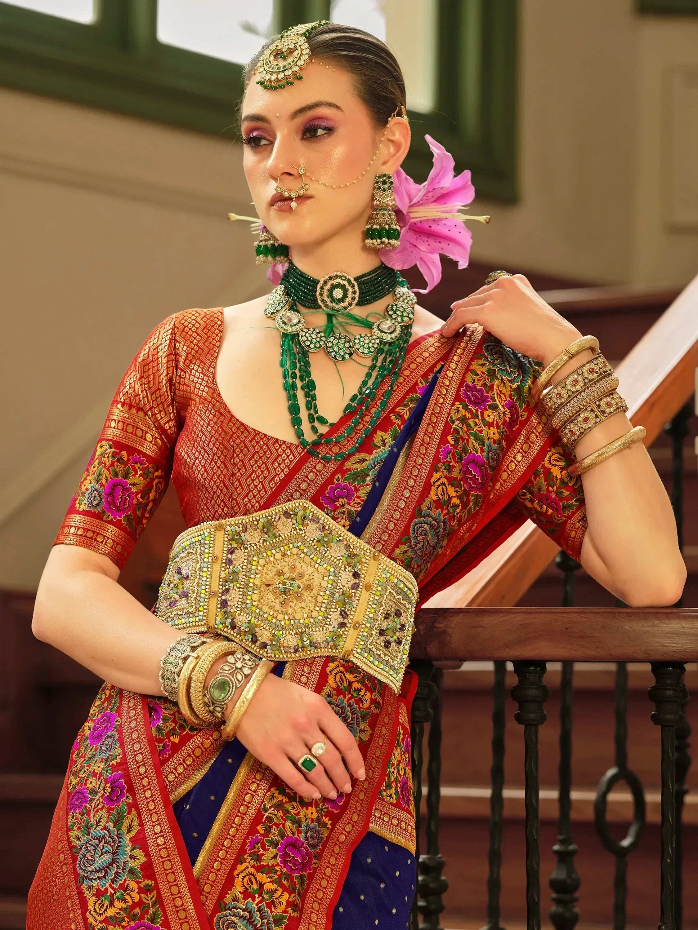 Woman in red floral saree with green jewelry, traditional Indian ethnic wear for weddings and festivals