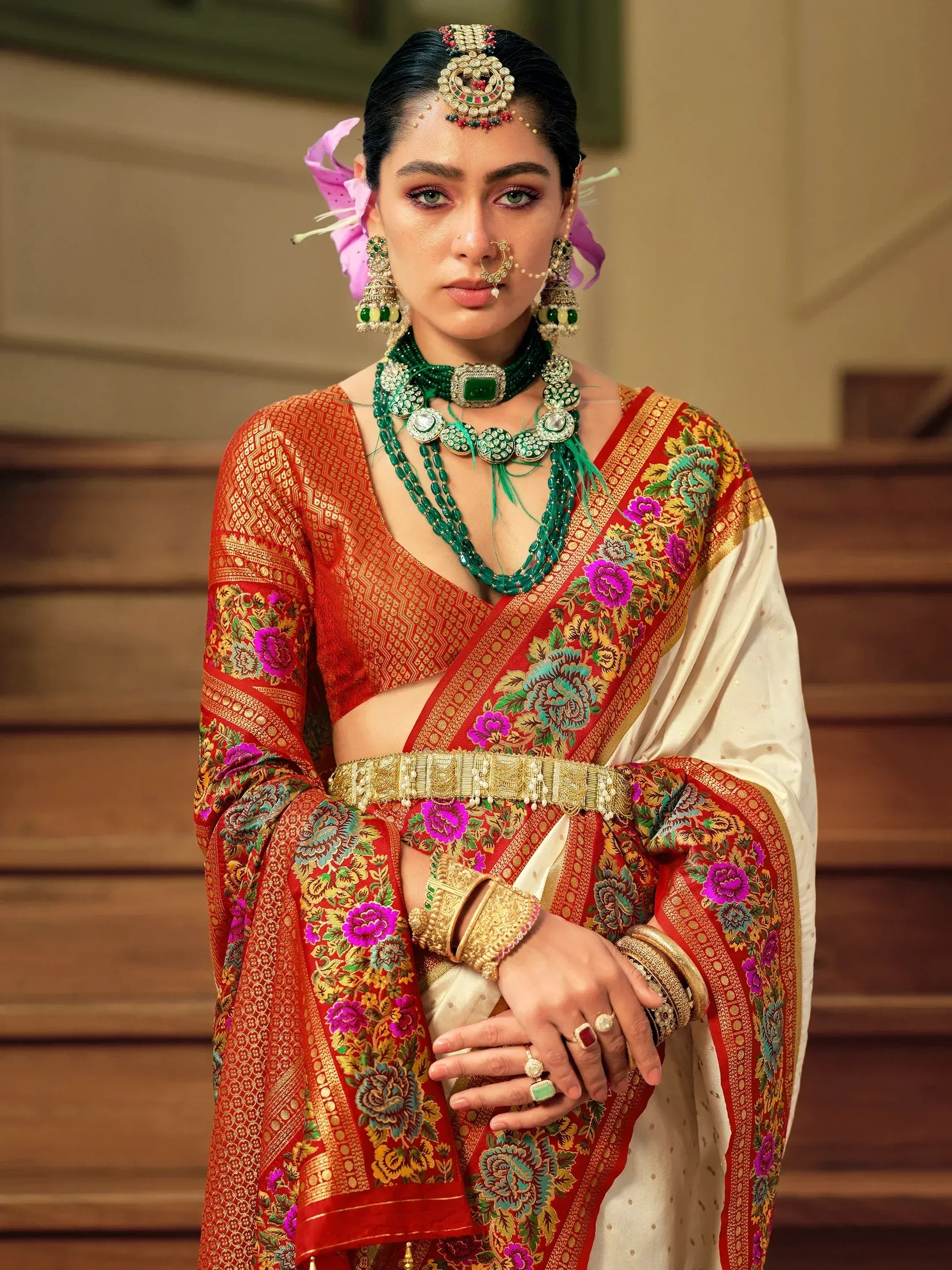 Woman in red and white floral saree with green jewelry, traditional Indian ethnic wear