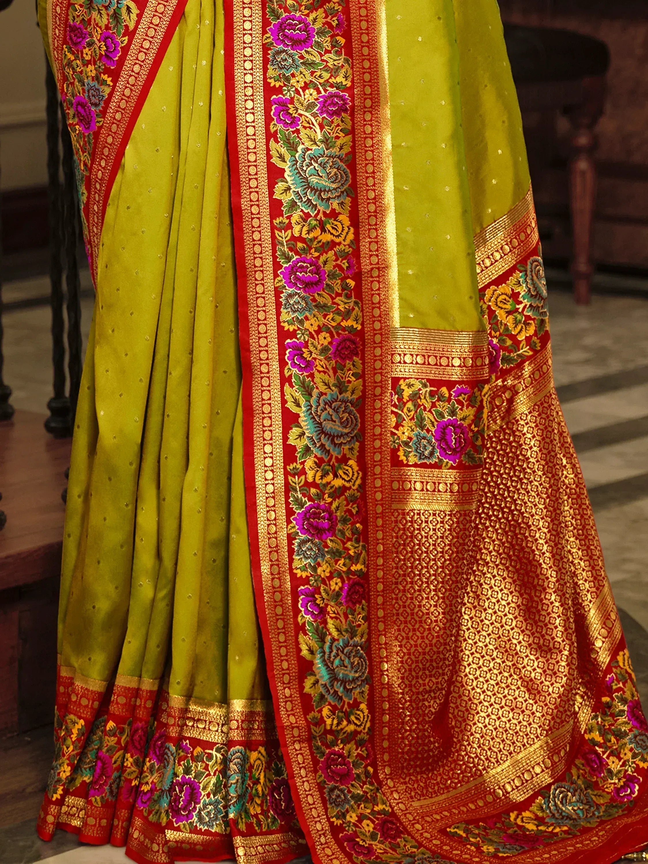 Vibrant green and red Indian saree with intricate floral embroidery and gold zari border, perfect for festive occasions.