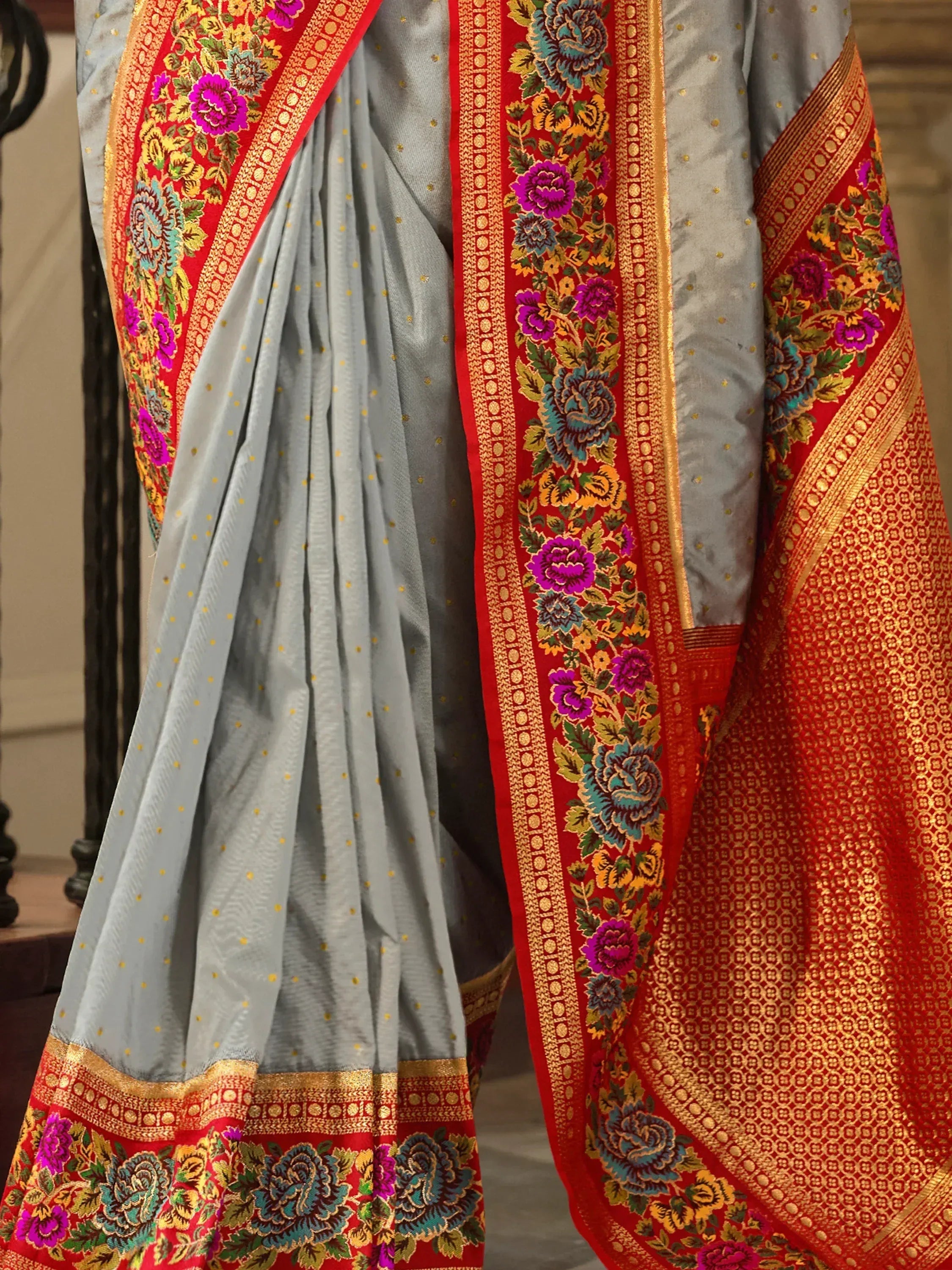 Grey saree with red floral border, gold zari work, and vibrant embroidery for Indian ethnic wear