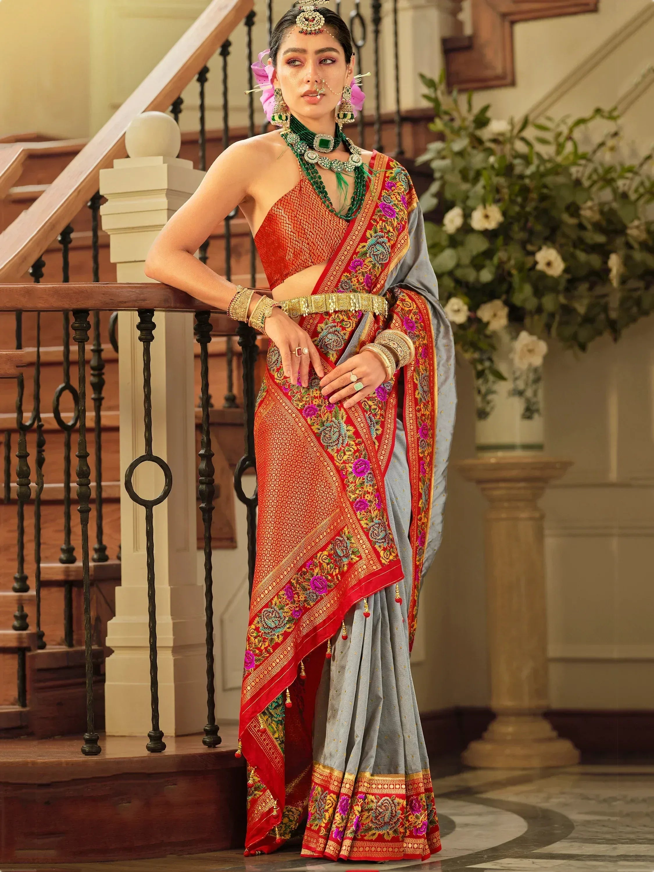 Woman in elegant Indian saree with floral embroidery, traditional jewelry, and grey-red dupatta, perfect for weddings.