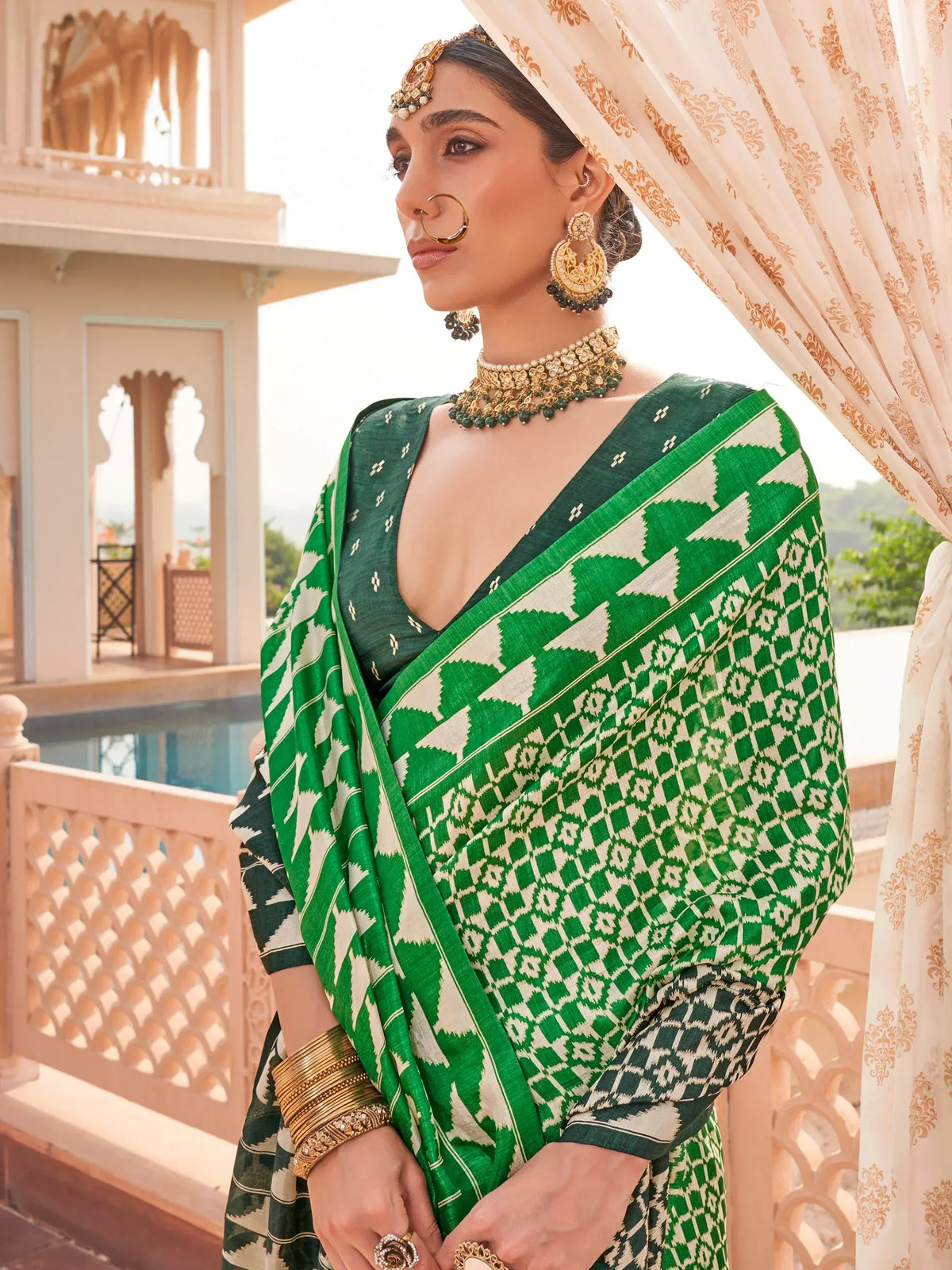Woman in green and white ikat saree with gold jewelry, traditional Indian ethnic wear