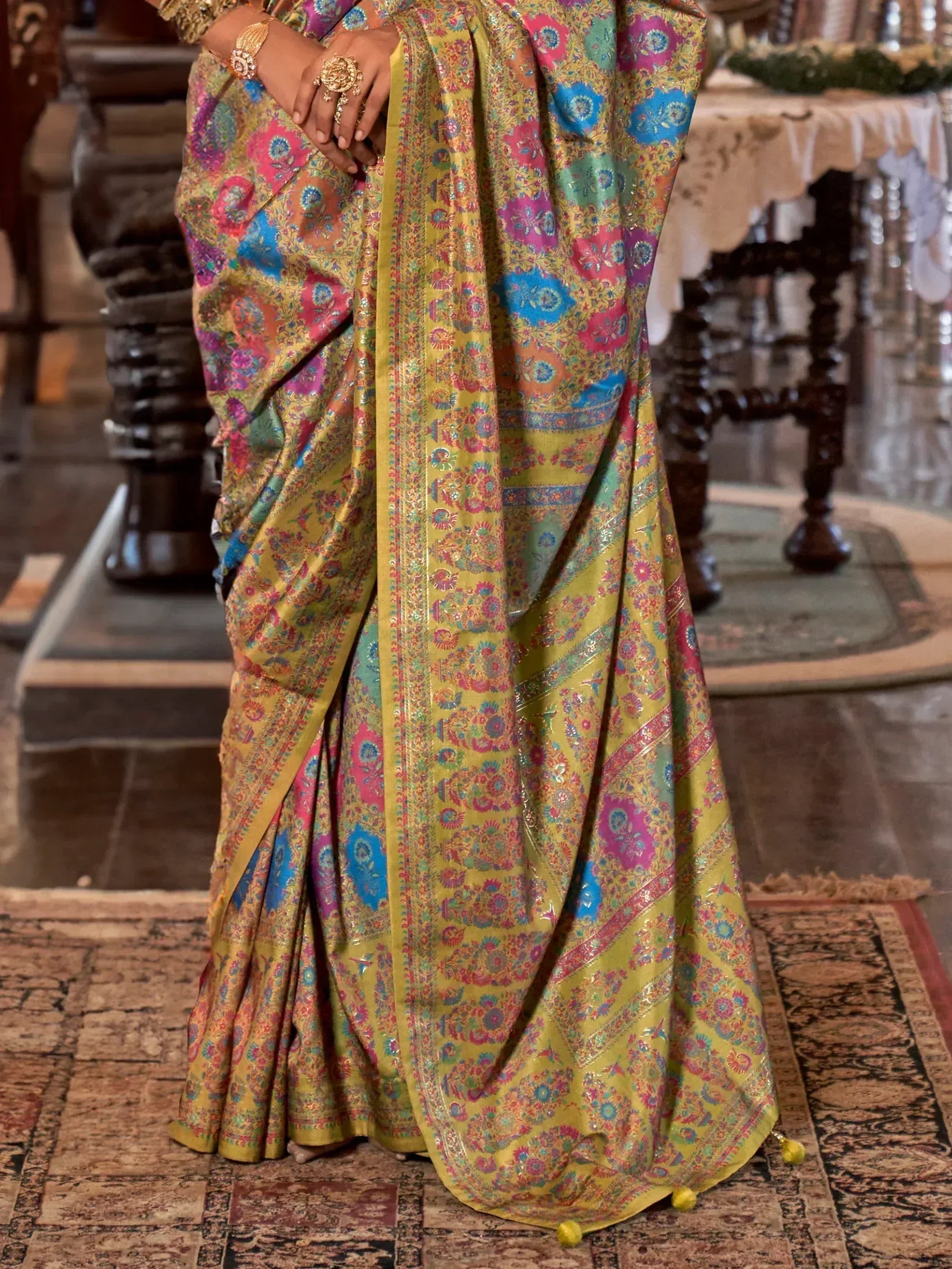 Vibrant yellow saree with colorful floral patterns and gold border, perfect for Indian ethnic wear.