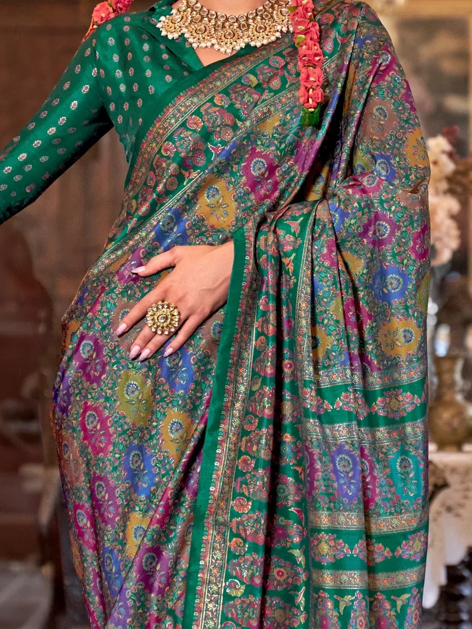 Green floral saree with intricate embroidery and gold jewelry, perfect for ethnic occasions.
