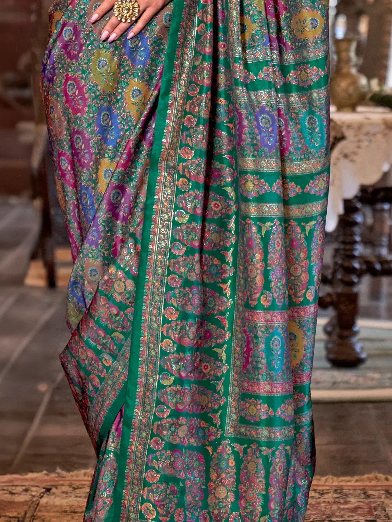 Vibrant green floral saree with intricate embroidery and colorful patterns, perfect for ethnic wear.
