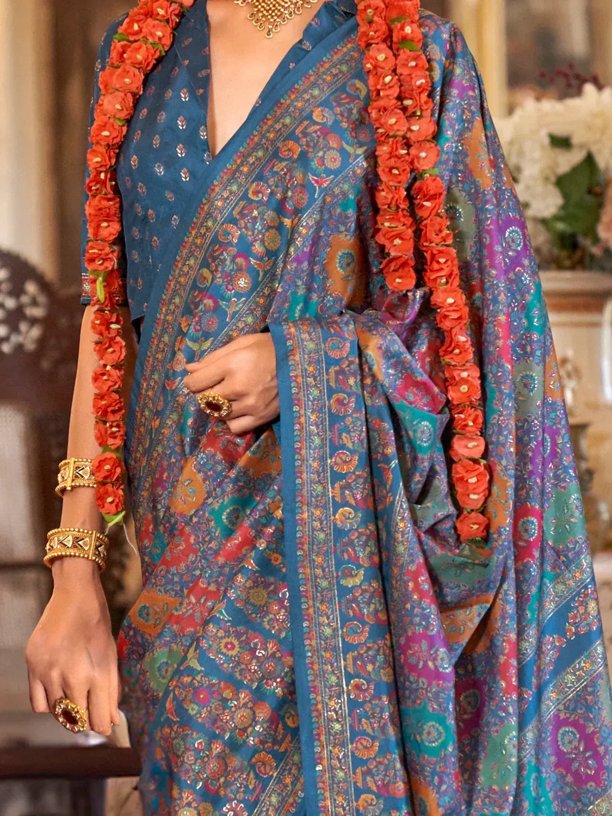 Blue floral saree with gold jewelry and red flower garland, Indian ethnic wear