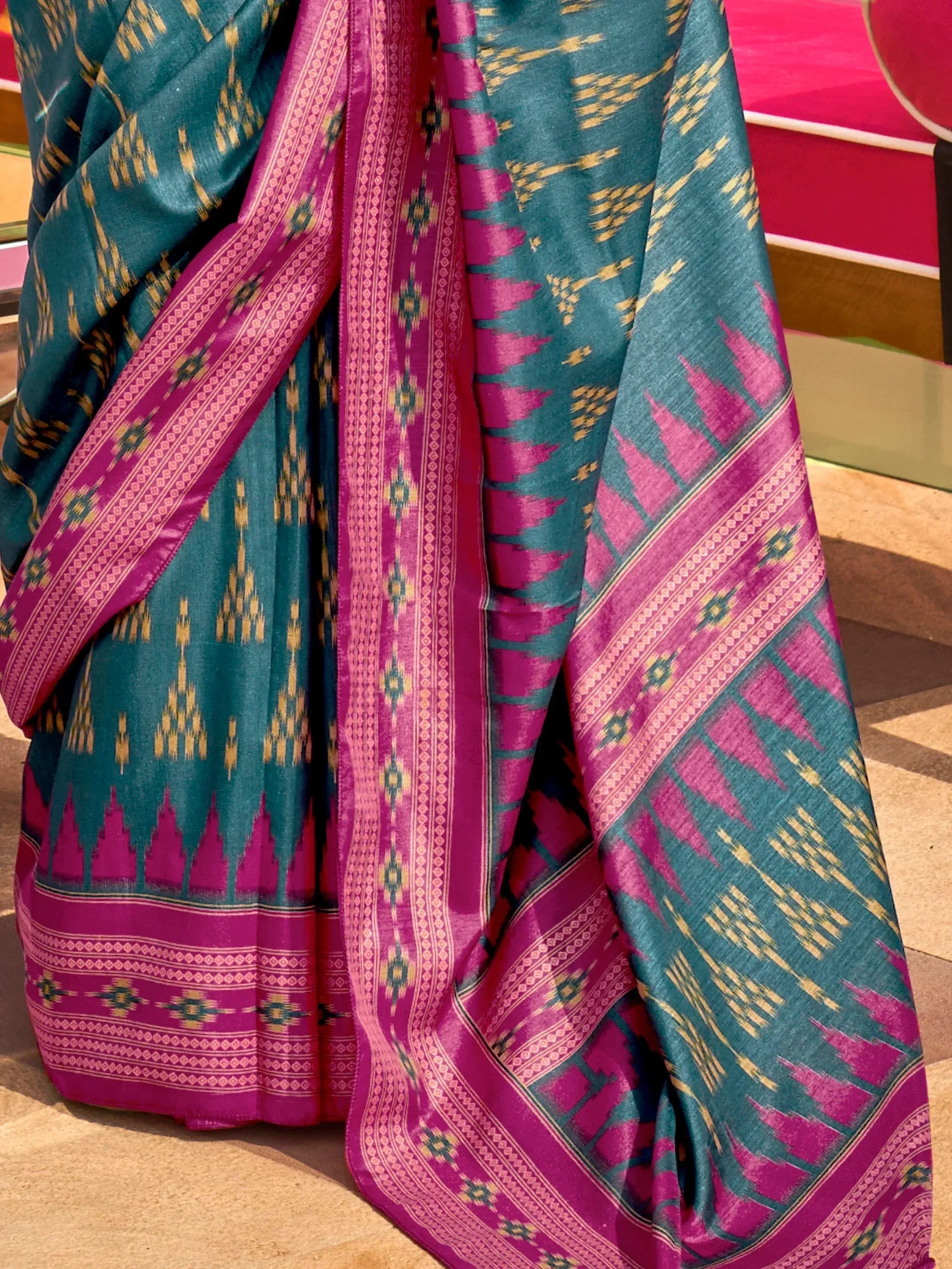 Teal and magenta ikat saree with geometric patterns and vibrant border design