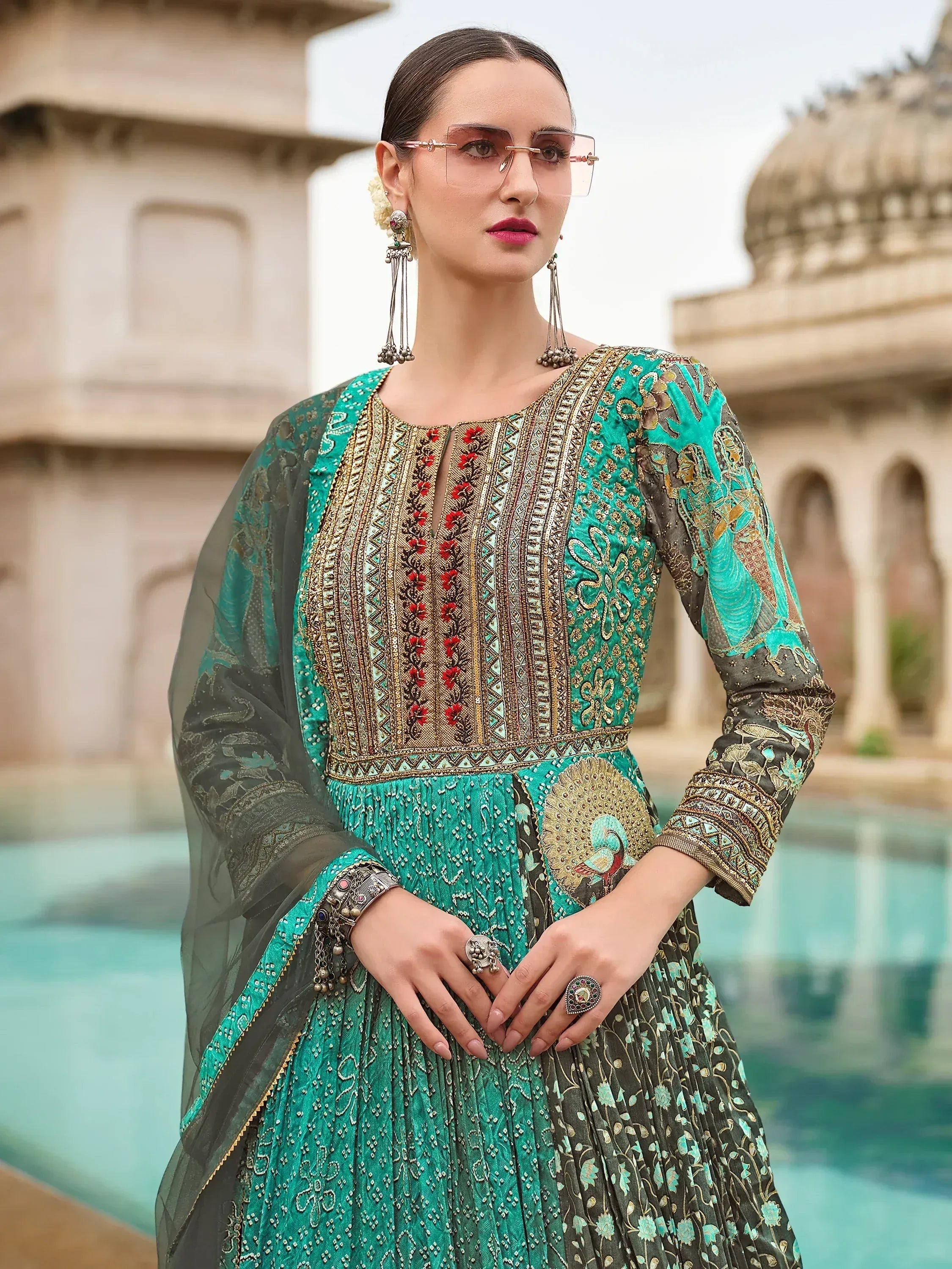 Elegant teal and black embroidered ethnic gown with peacock motif, perfect for Indian festive occasions.
