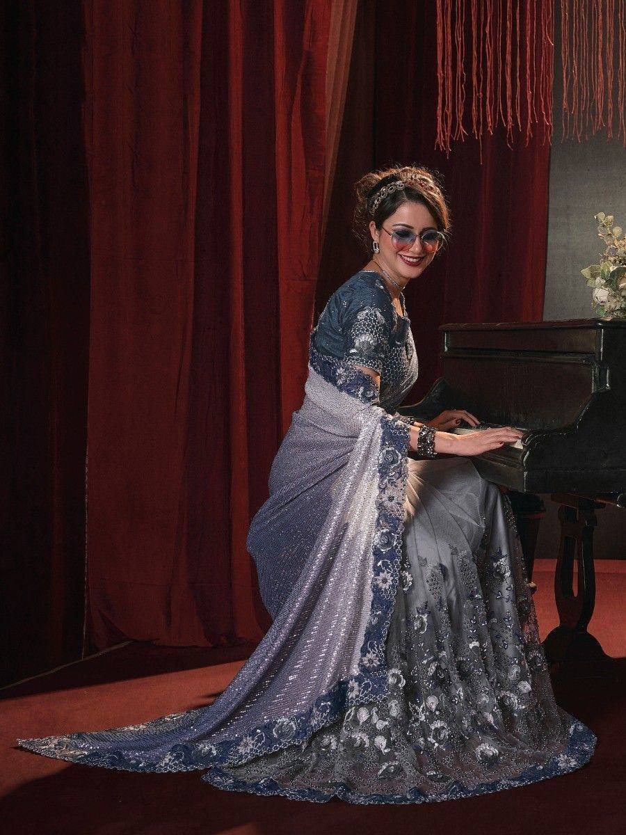 Woman in elegant blue and silver embroidered saree playing piano, Indian ethnic wear