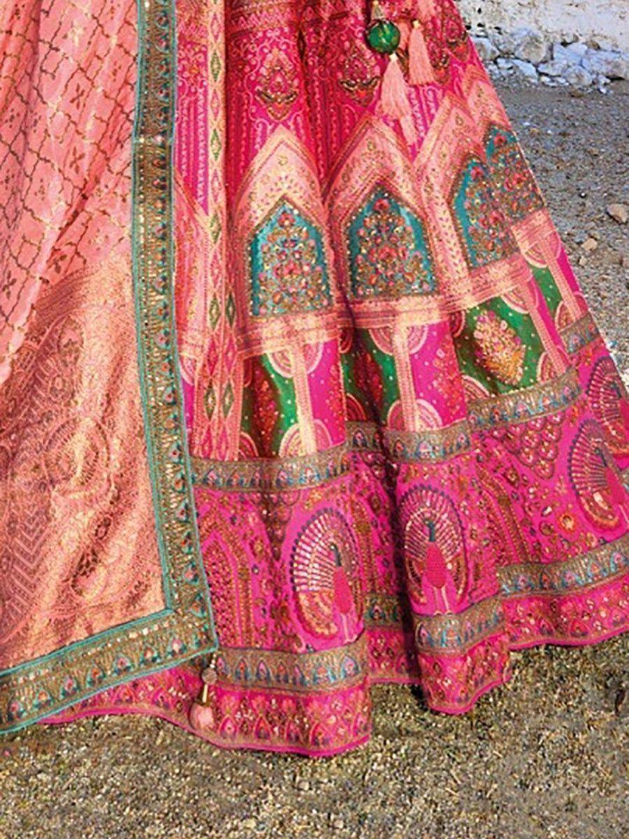 Vibrant pink and green embroidered lehenga with peacock motifs and detailed border, ideal for Indian ethnic wear.