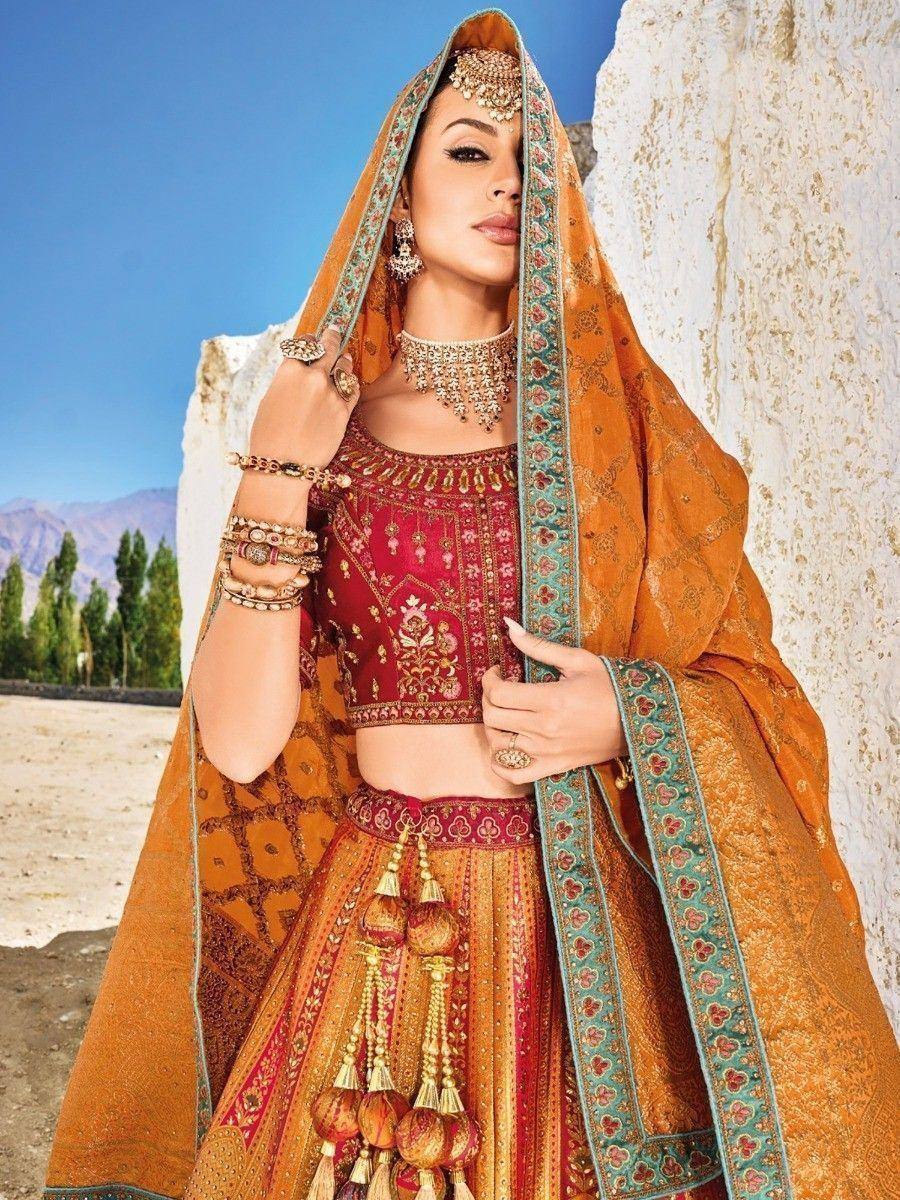 Elegant Indian lehenga choli with intricate embroidery, orange dupatta, and traditional jewelry for ethnic wear