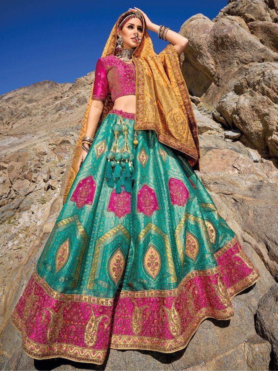 Teal and pink designer lehenga choli with gold embroidery, perfect for Indian weddings and festive occasions.