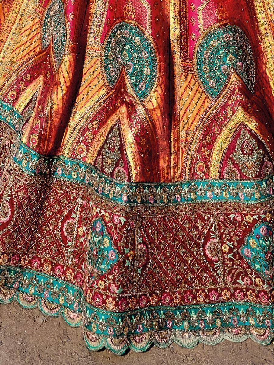 Richly embroidered Indian lehenga with intricate paisley and floral motifs in red, gold, and teal