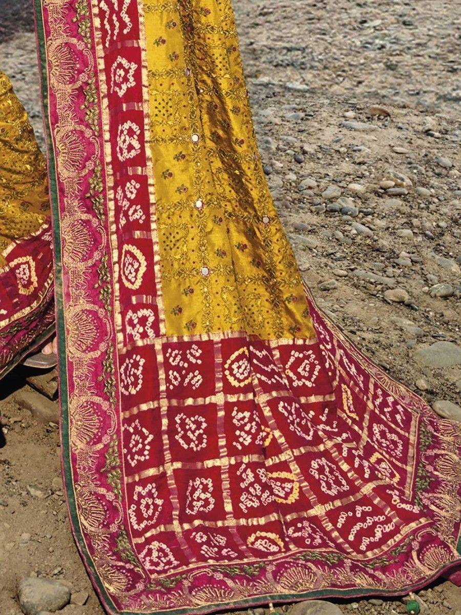 Yellow and maroon ethnic saree with intricate embroidery and mirror work, perfect for Indian weddings and festivals.