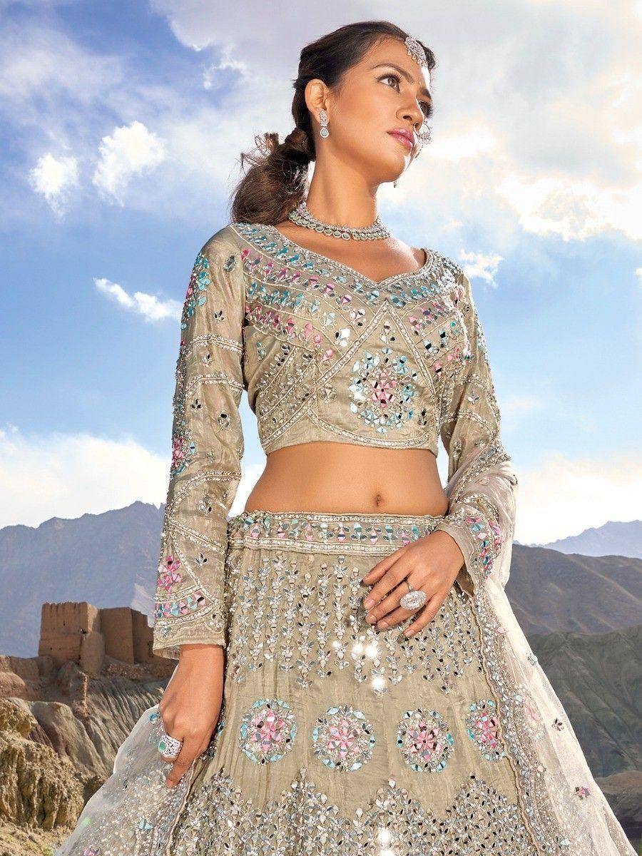 Elegant beige lehenga choli with mirror and floral embroidery, perfect for Indian weddings and festive occasions.