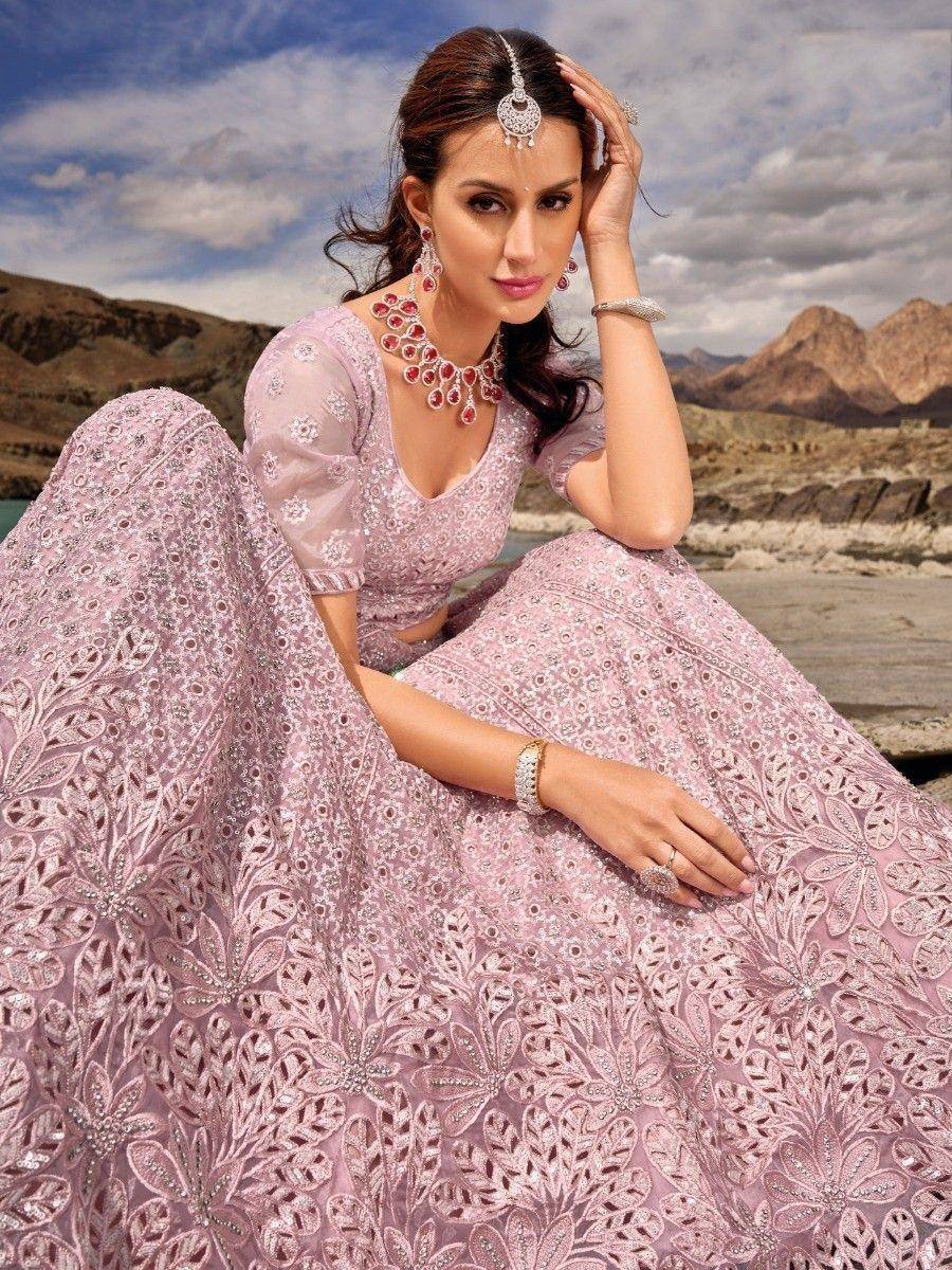 Elegant pink designer lehenga choli with intricate floral embroidery and red gemstone jewelry, perfect for Indian ethnic wear.
