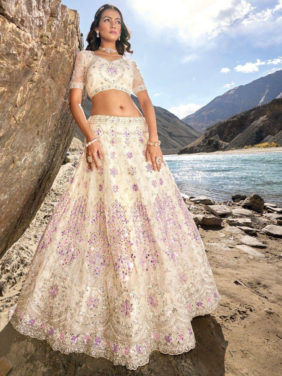 Elegant cream lehenga choli with purple floral embroidery, perfect for Indian ethnic wear occasions.
