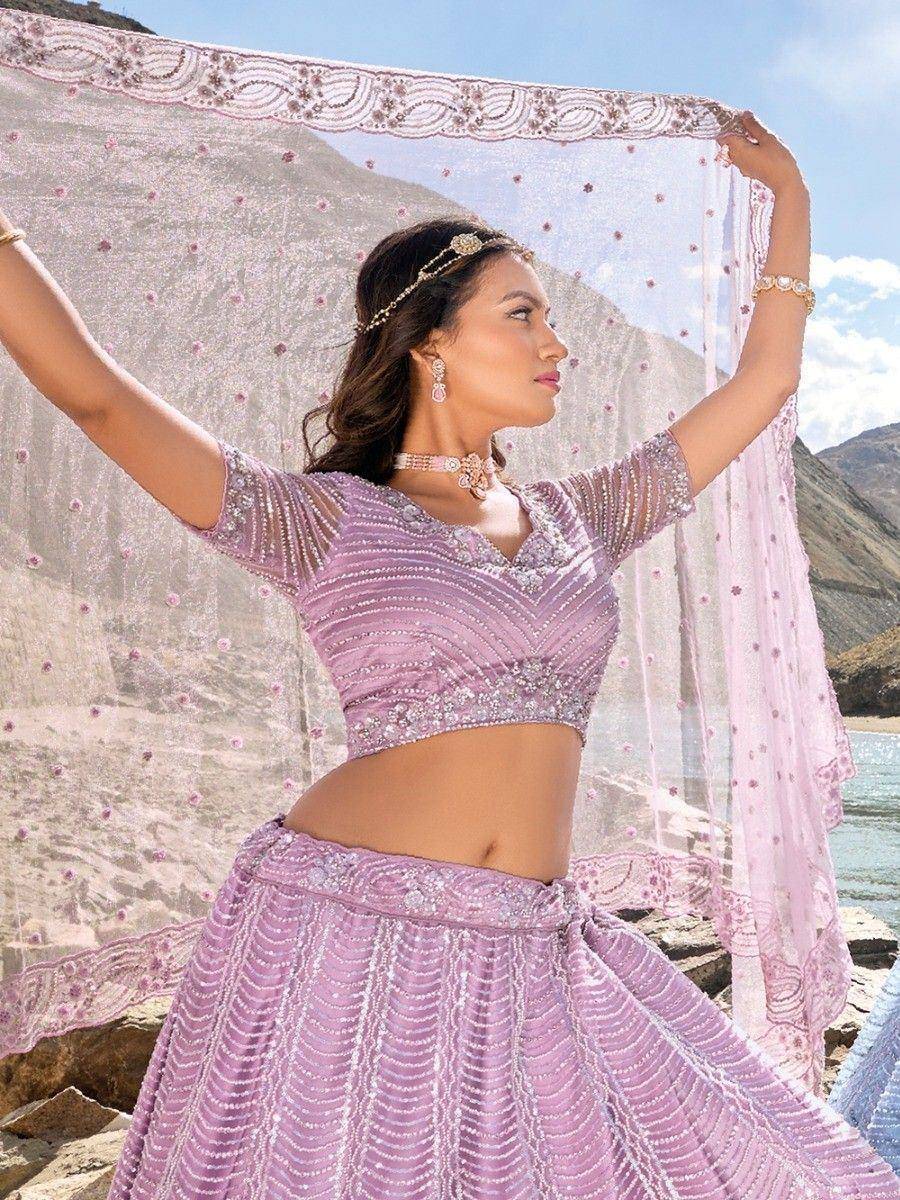 Woman in lavender designer lehenga choli with embellished dupatta, mountain backdrop