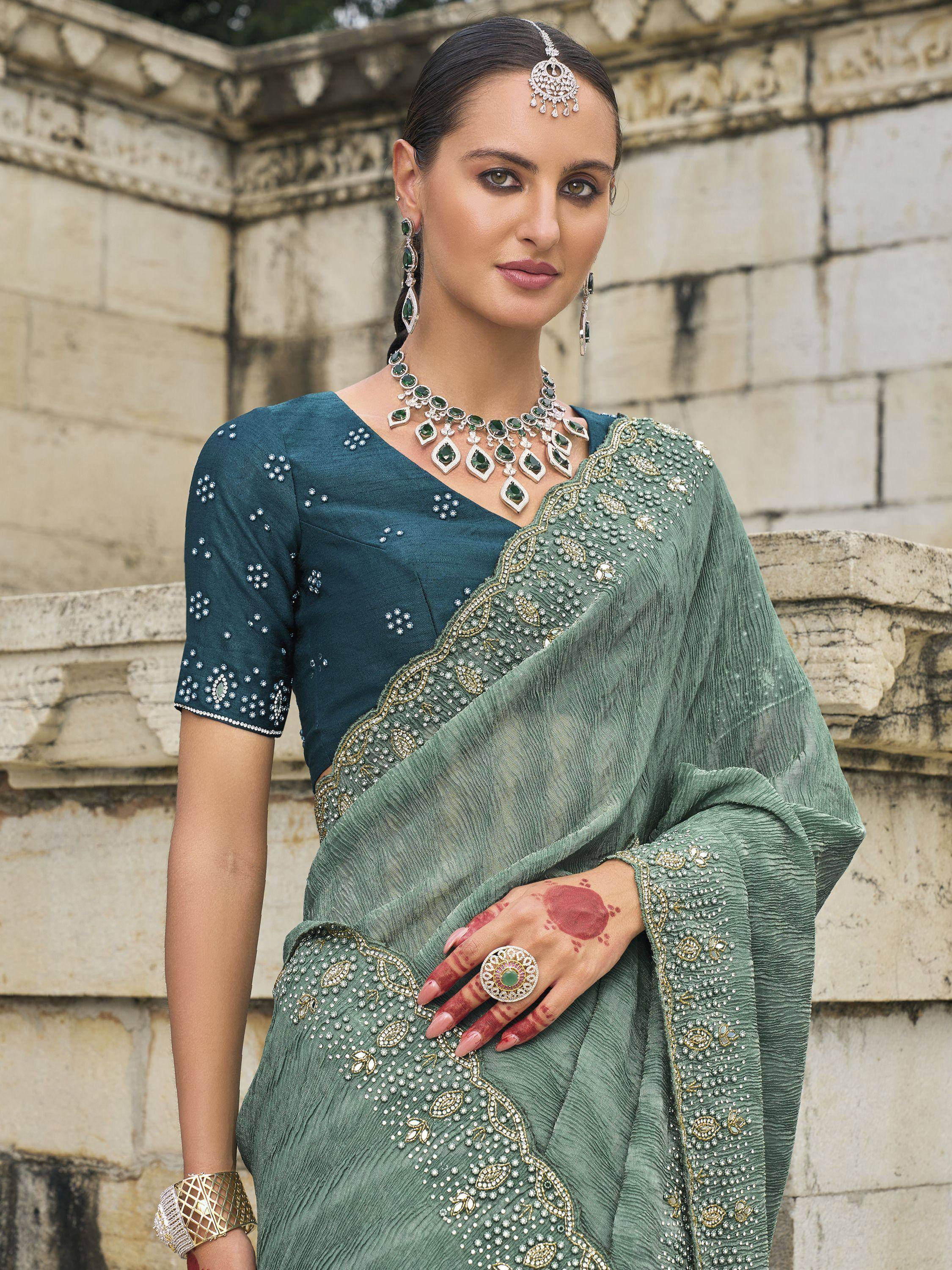 Elegant green embroidered saree with matching blouse, traditional Indian jewelry, and henna design
