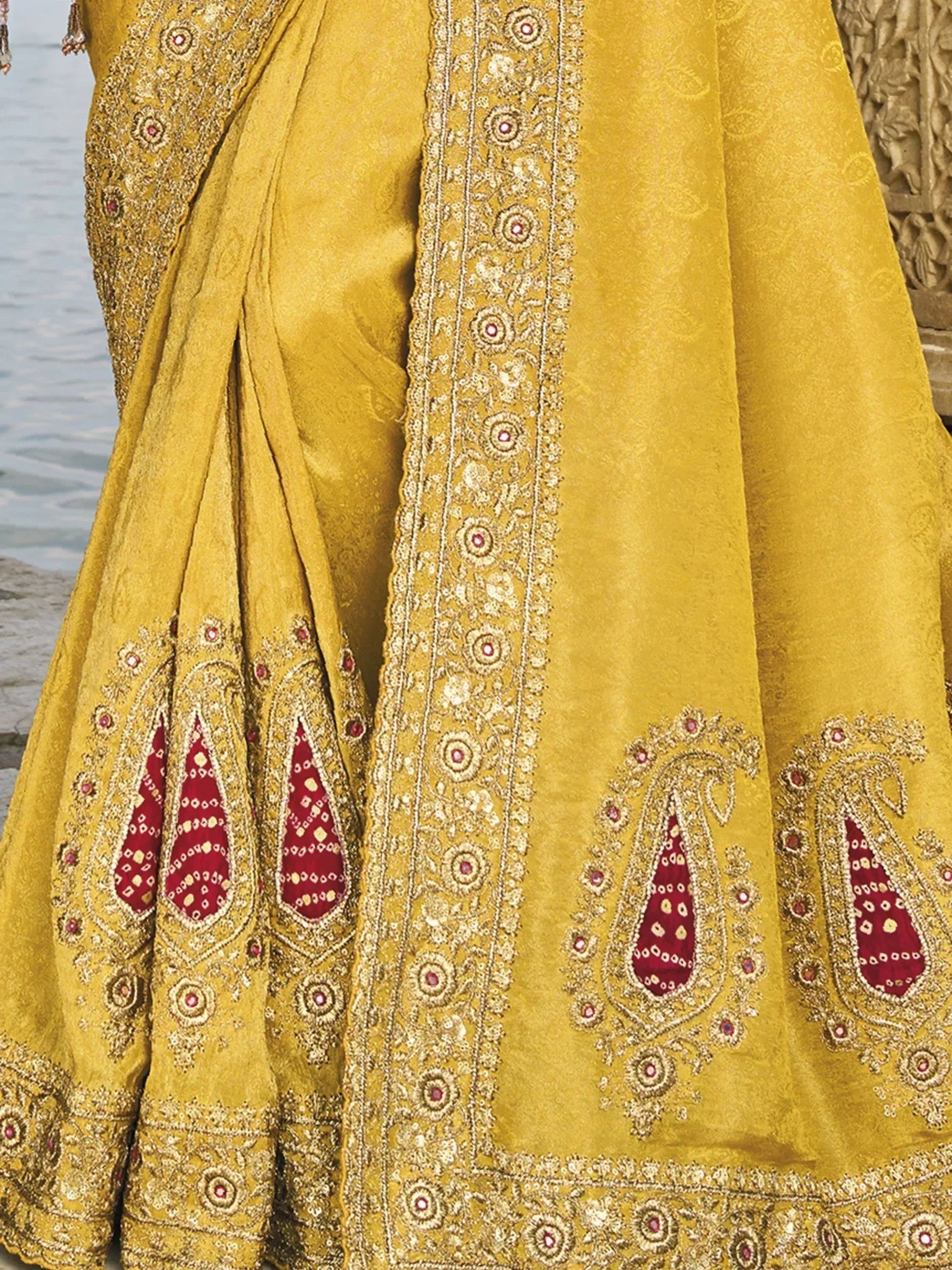 Yellow designer lehenga with red paisley embroidery and gold detailing, perfect for Indian ethnic wear.