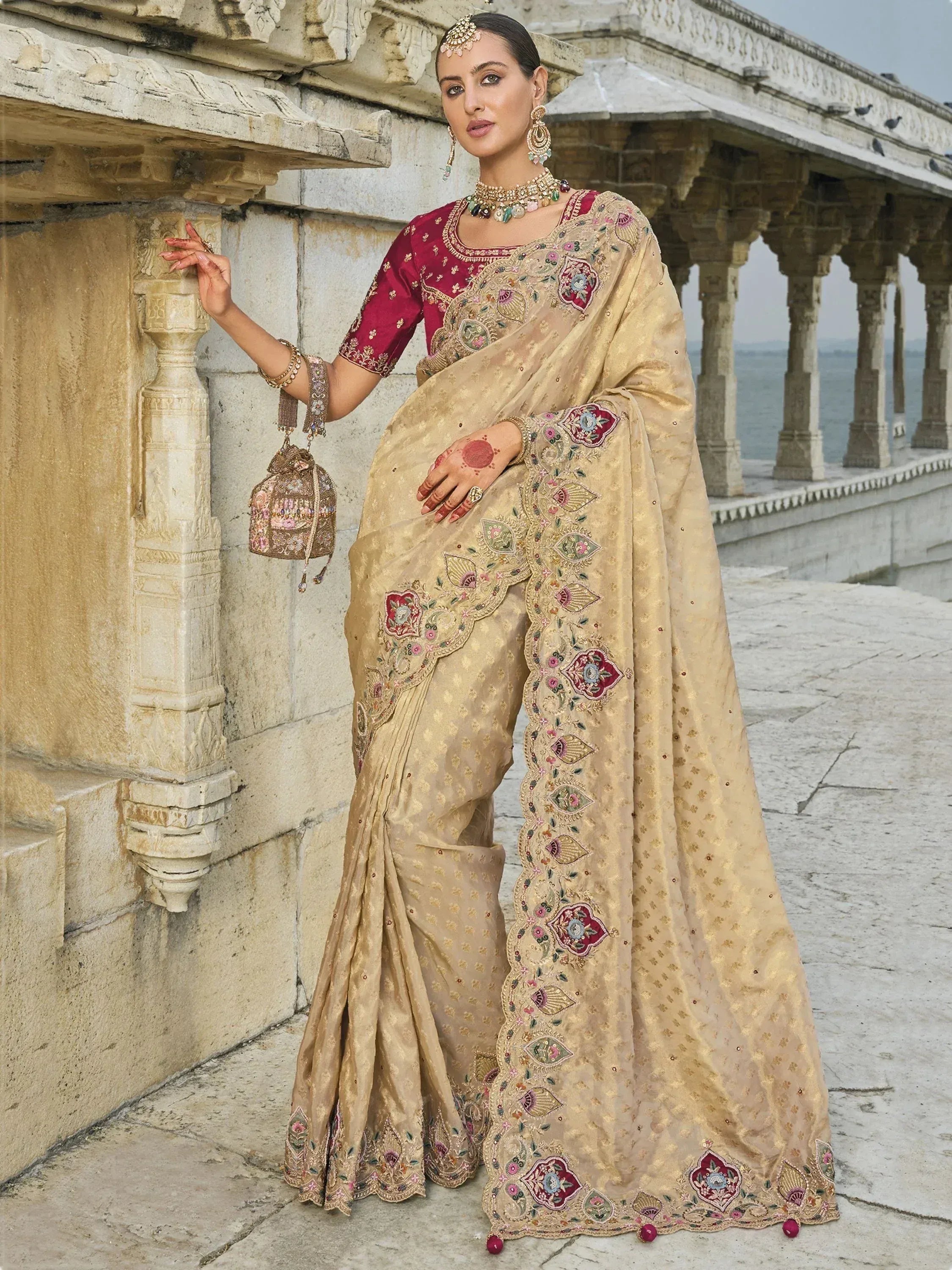 Elegant beige saree with maroon blouse, intricate floral embroidery, and traditional jewelry for Indian ethnic wear