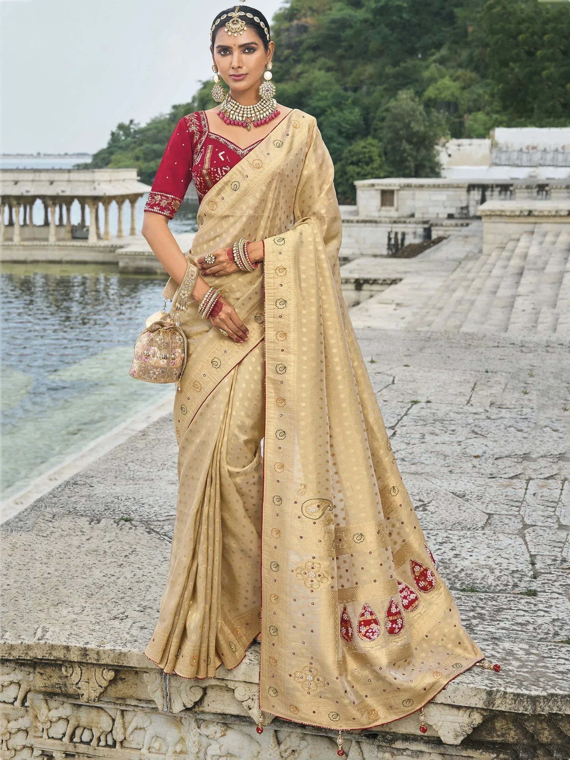 Elegant beige saree with red blouse, gold embroidery, and traditional jewelry for Indian ethnic wear.