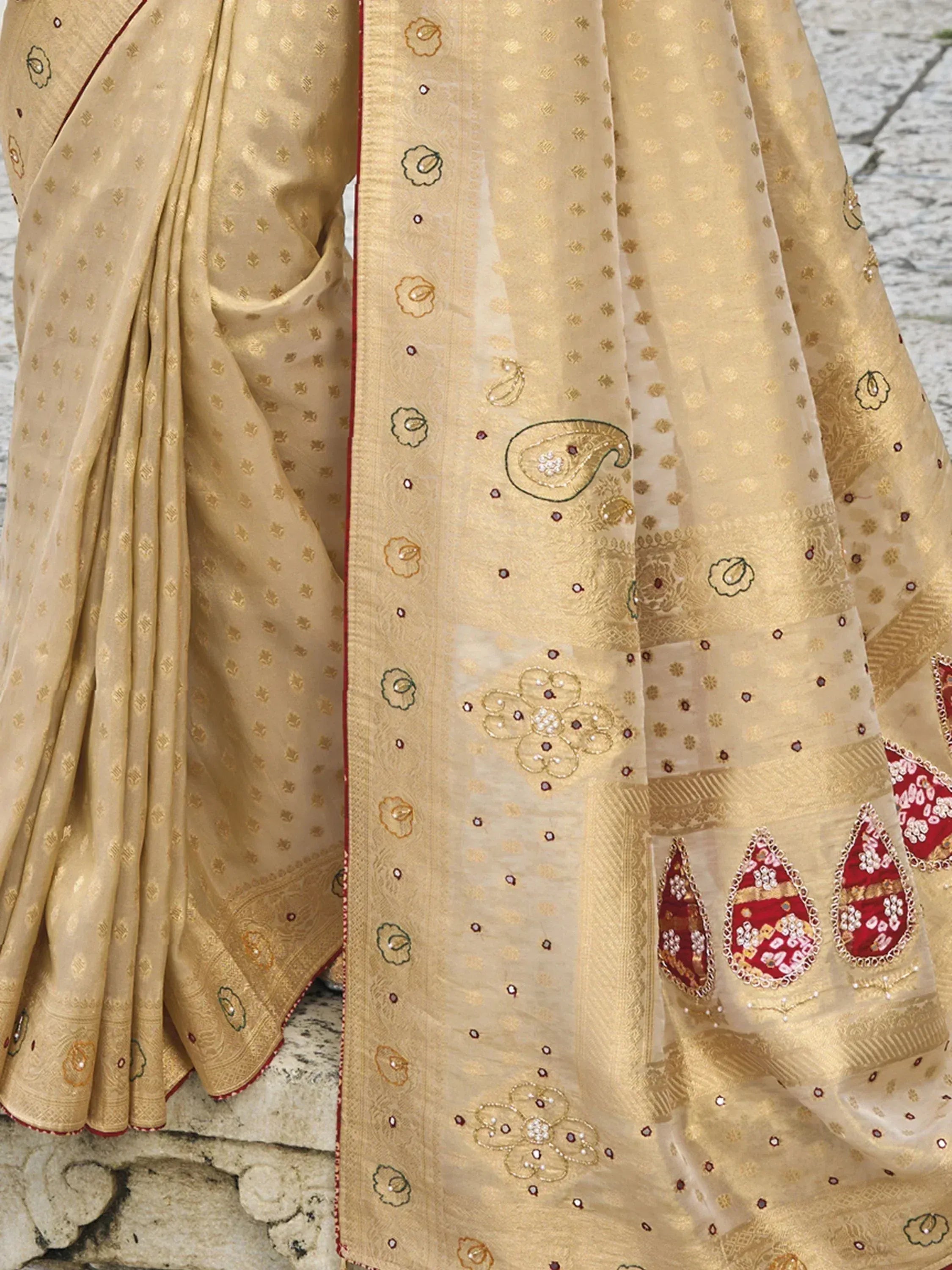 Beige embroidered saree with gold paisley and red floral motifs, perfect for Indian ethnic wear