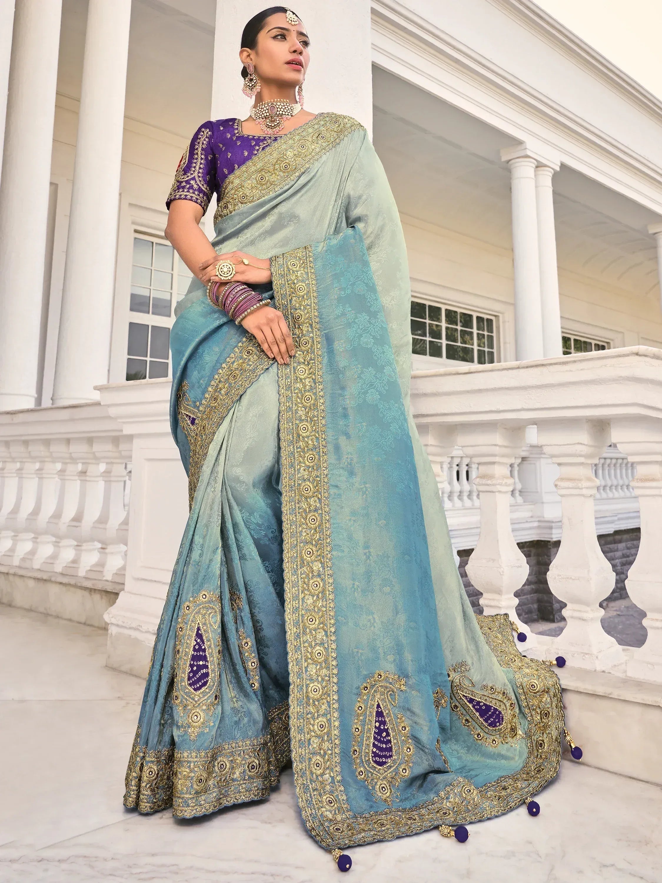 Elegant blue-green saree with gold embroidery and purple blouse, perfect for Indian ethnic occasions.