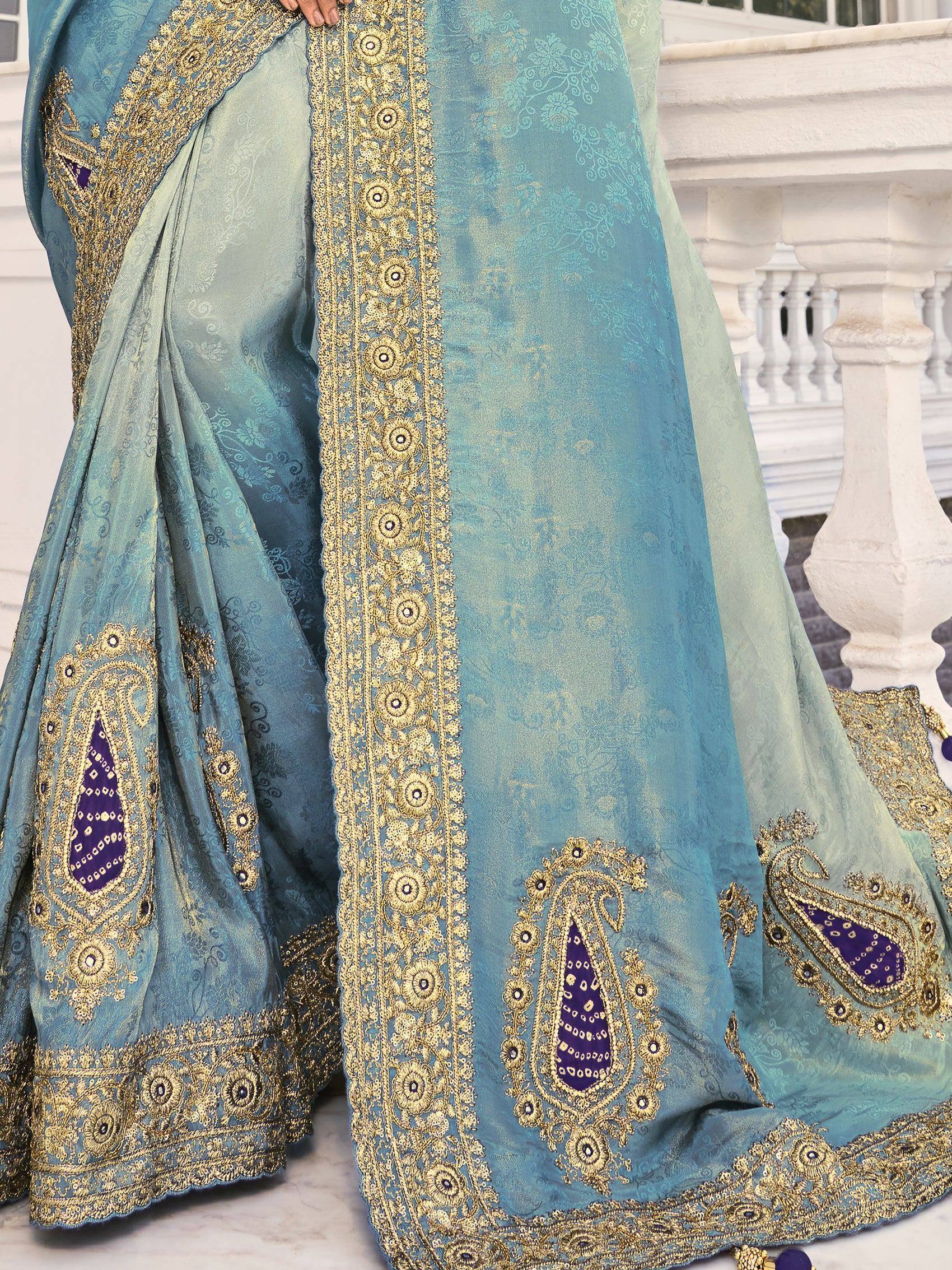 Blue designer saree with gold embroidery and purple paisley motifs, ideal for ethnic occasions