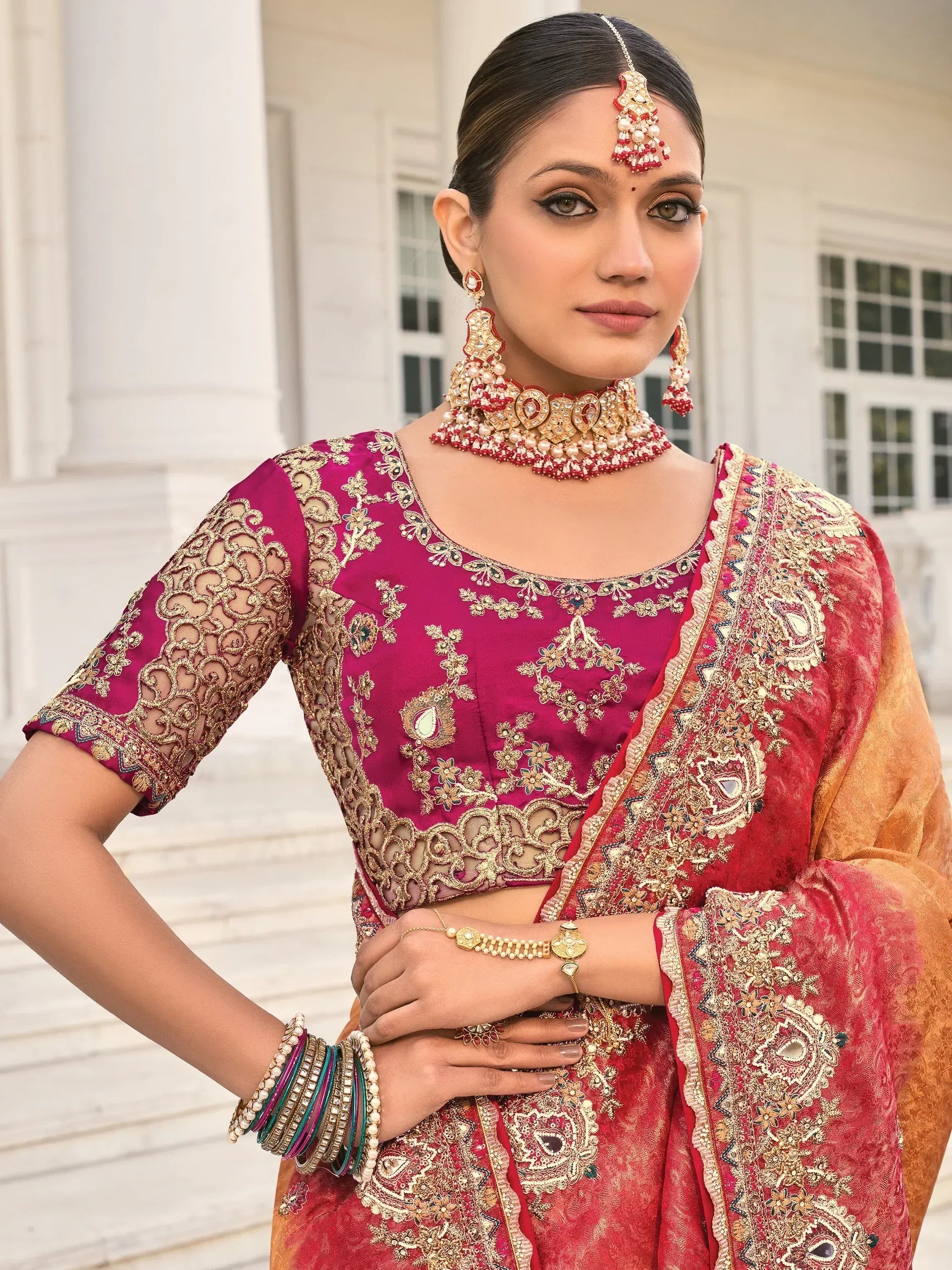 Elegant maroon and gold embroidered lehenga choli with traditional Indian jewelry